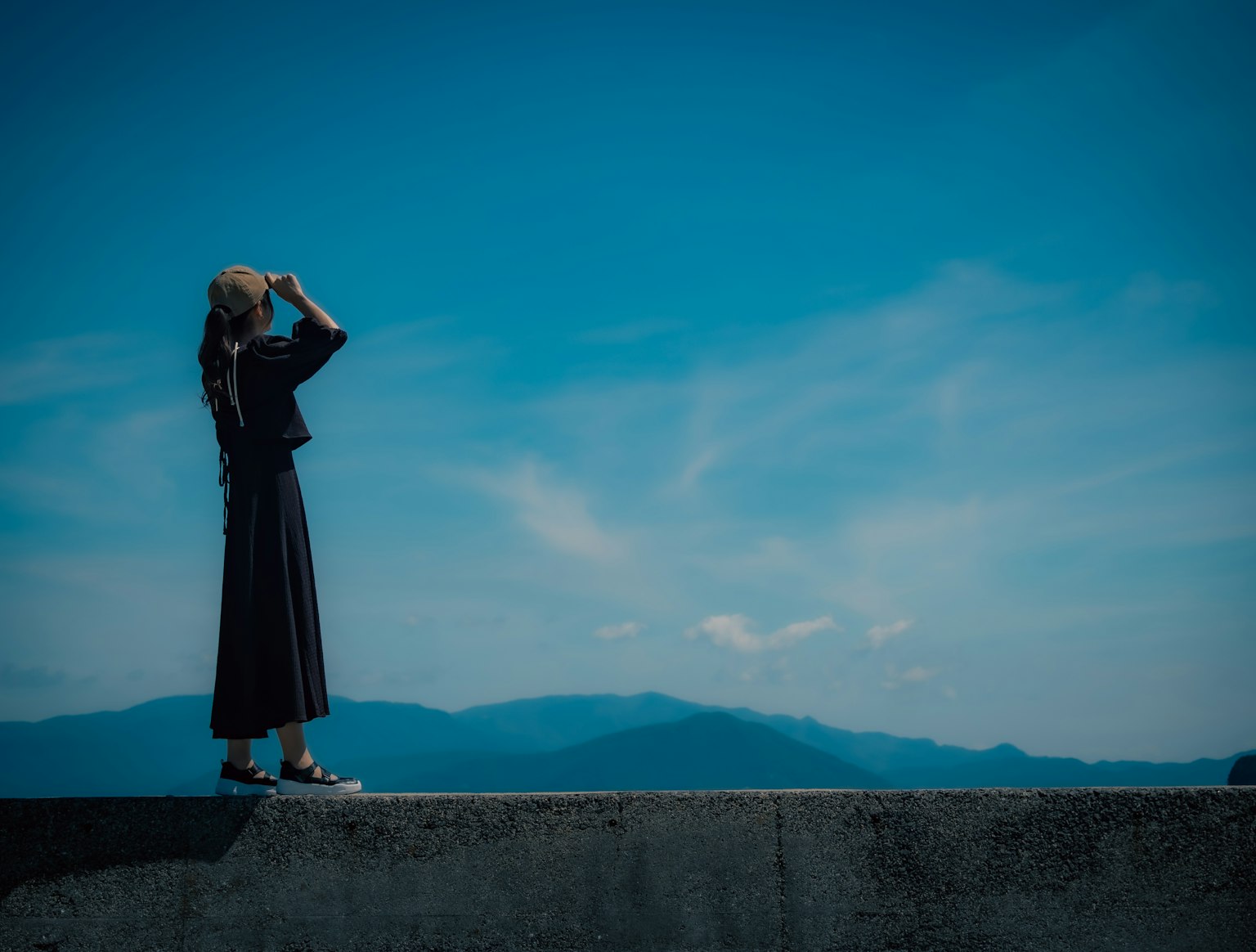蓝天之下凝视远方的女性剪影