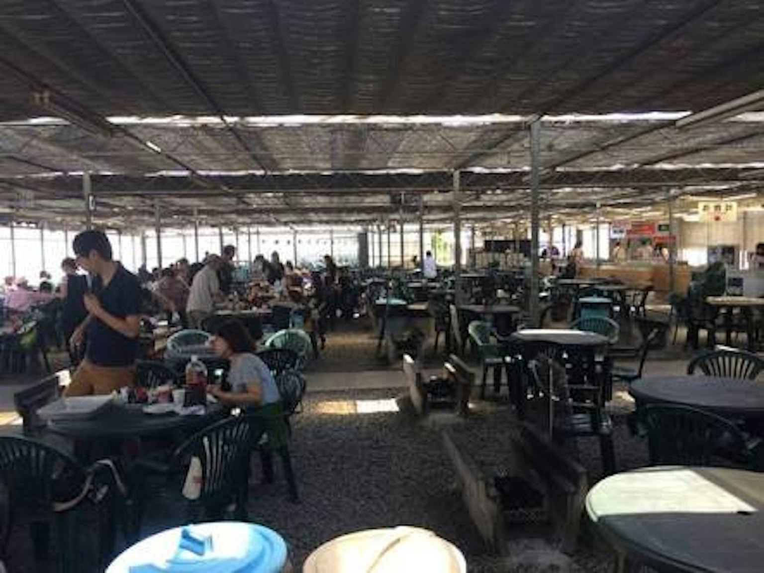 宽敞的室内就餐区，有桌子和享受餐点的人