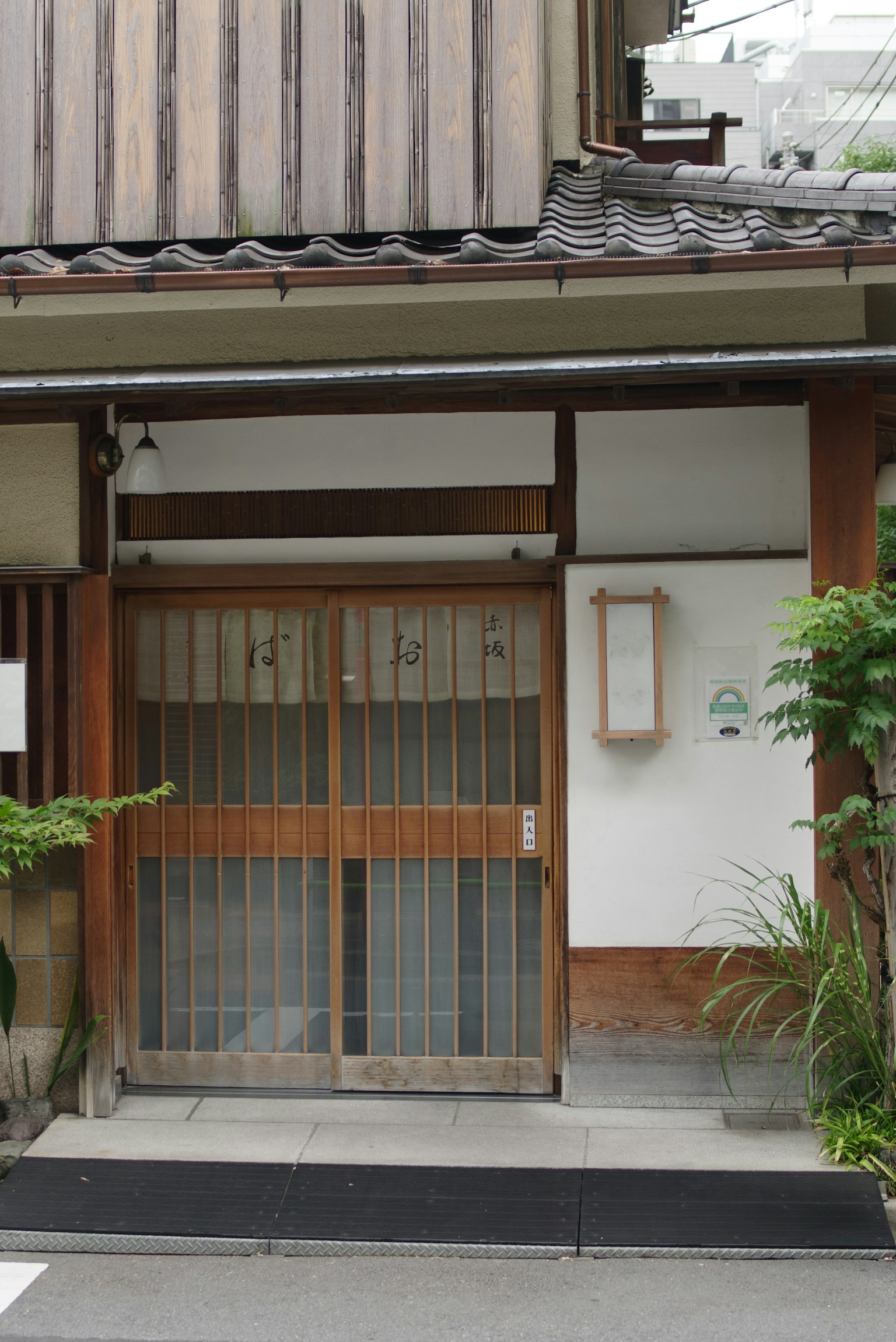 Traditional Japanese house with wooden sliding door and greenery