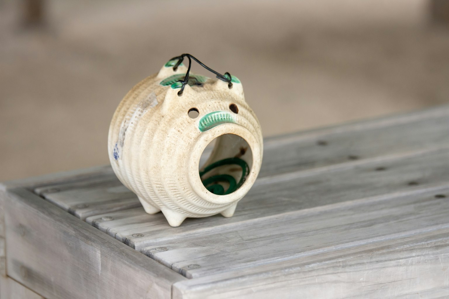Una pigotta in ceramica bianca con una faccia carina posata su un tavolo di legno