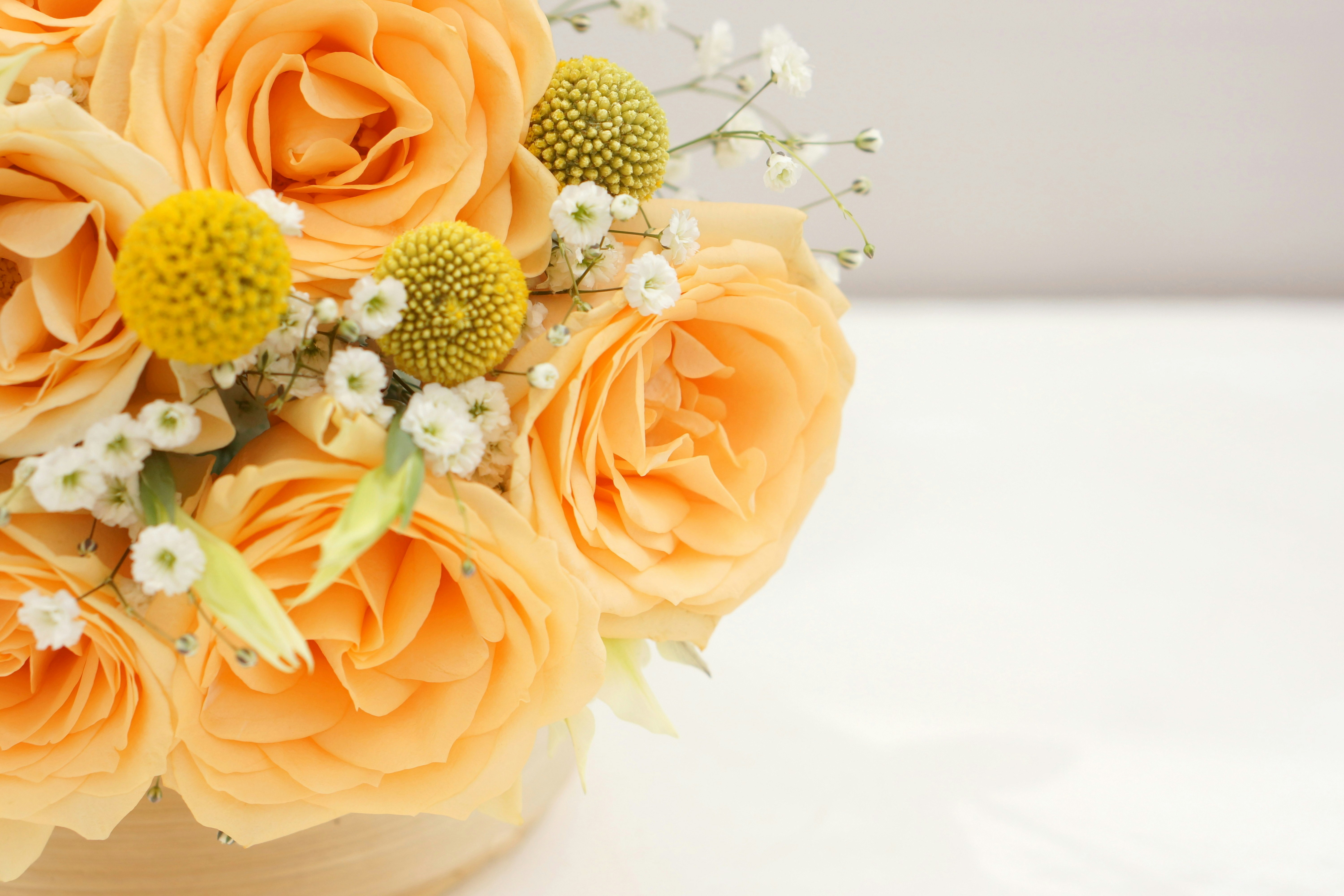 オレンジのバラの花束と小花のクローズアップ
