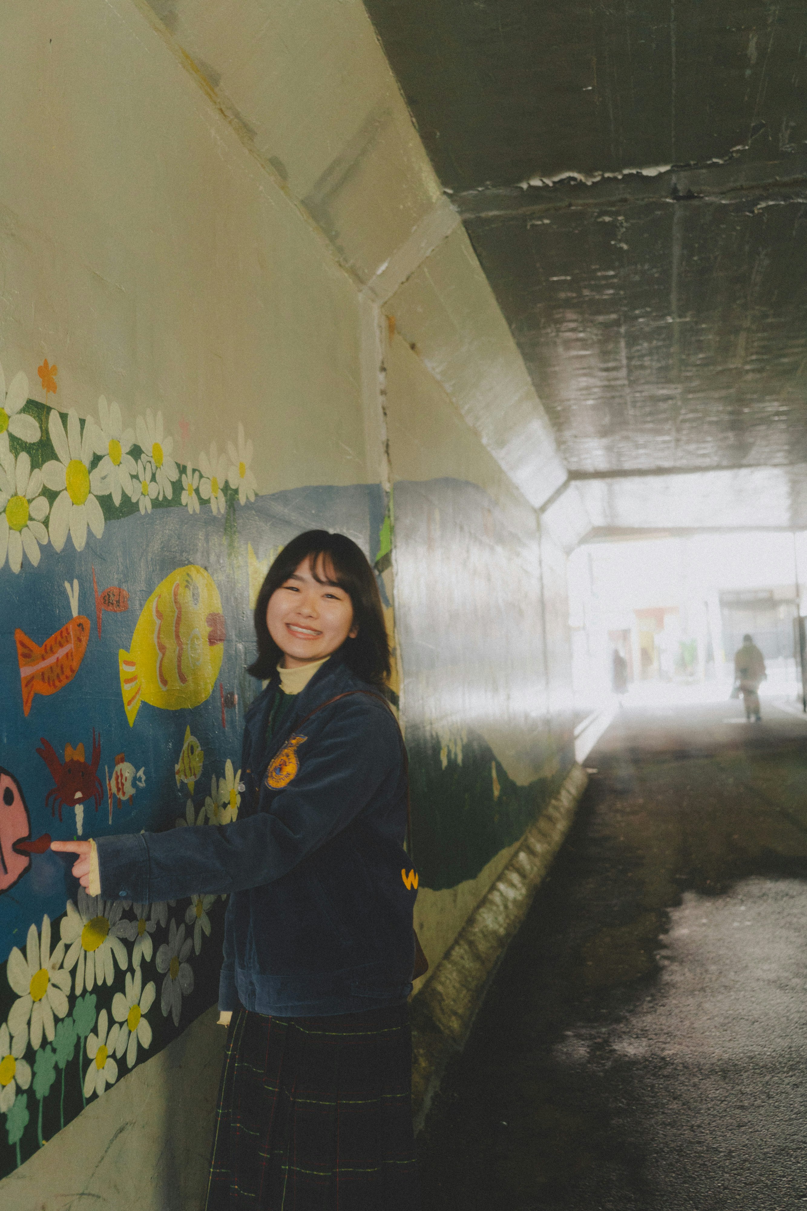 壁の落書きと花の装飾がある路地で笑顔の女性