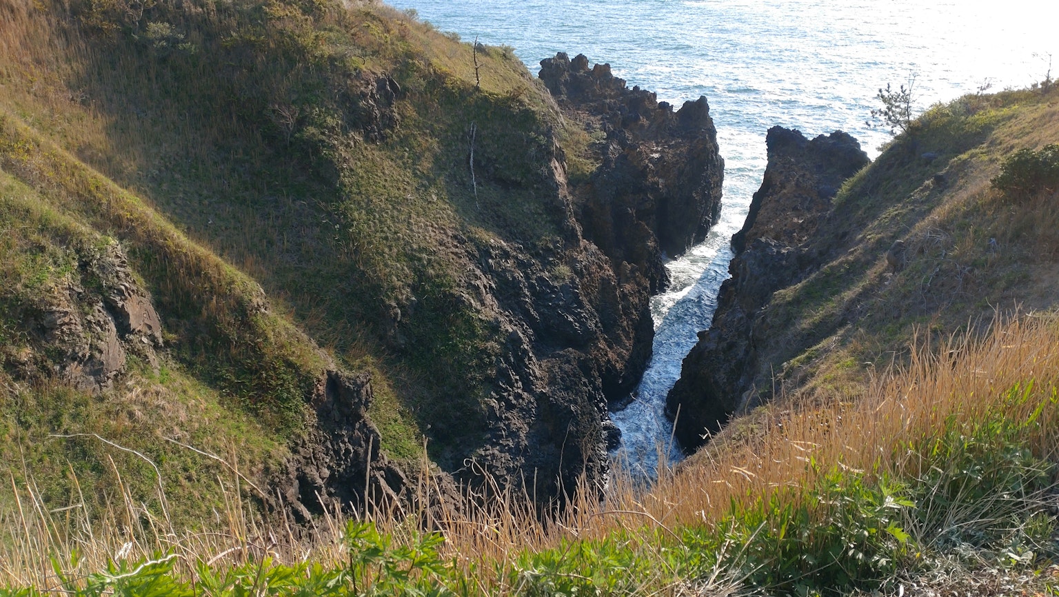 Blick auf Wasser, das zwischen steilen Klippen zum Meer fließt