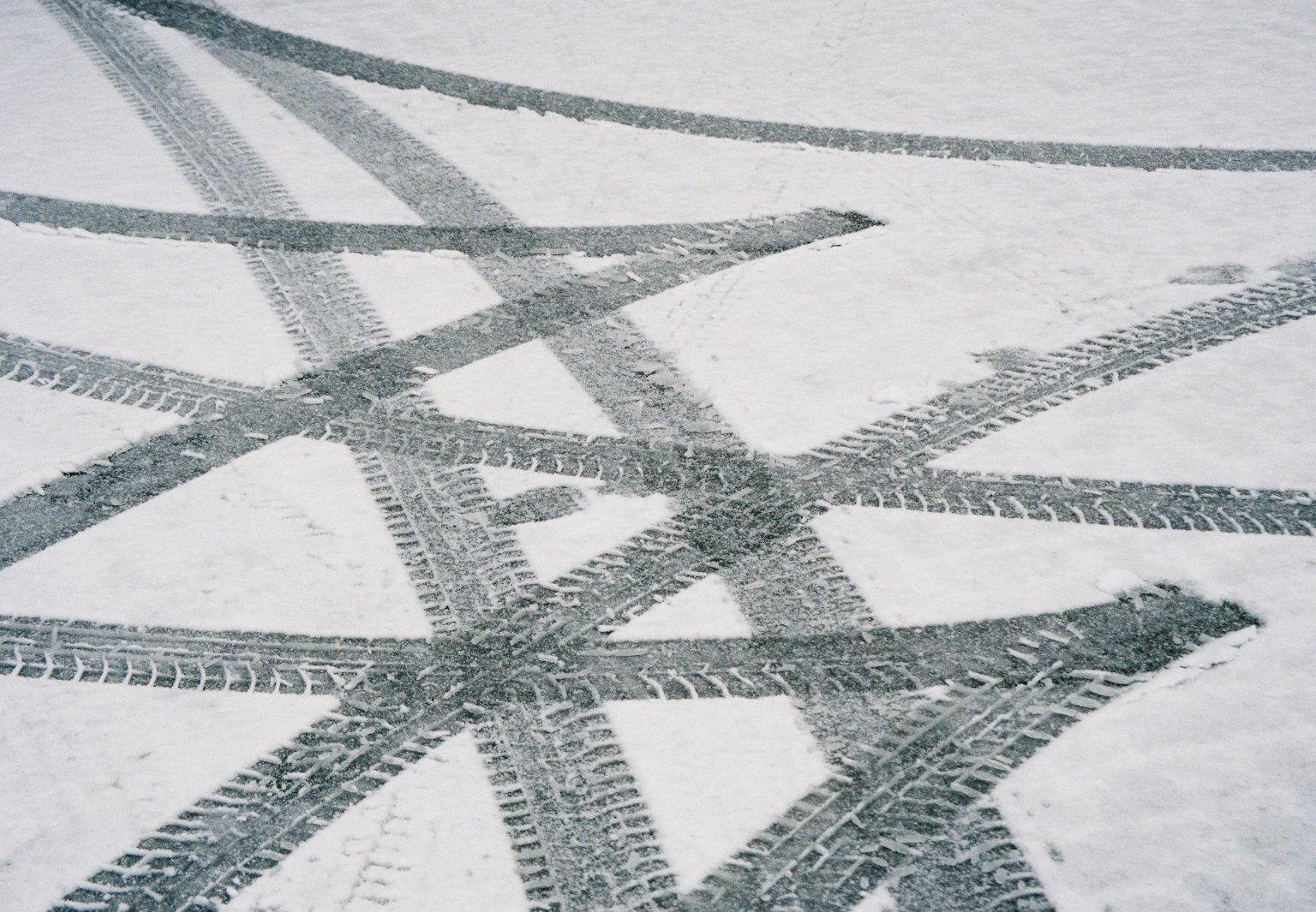 交错的轮胎痕迹在雪地上