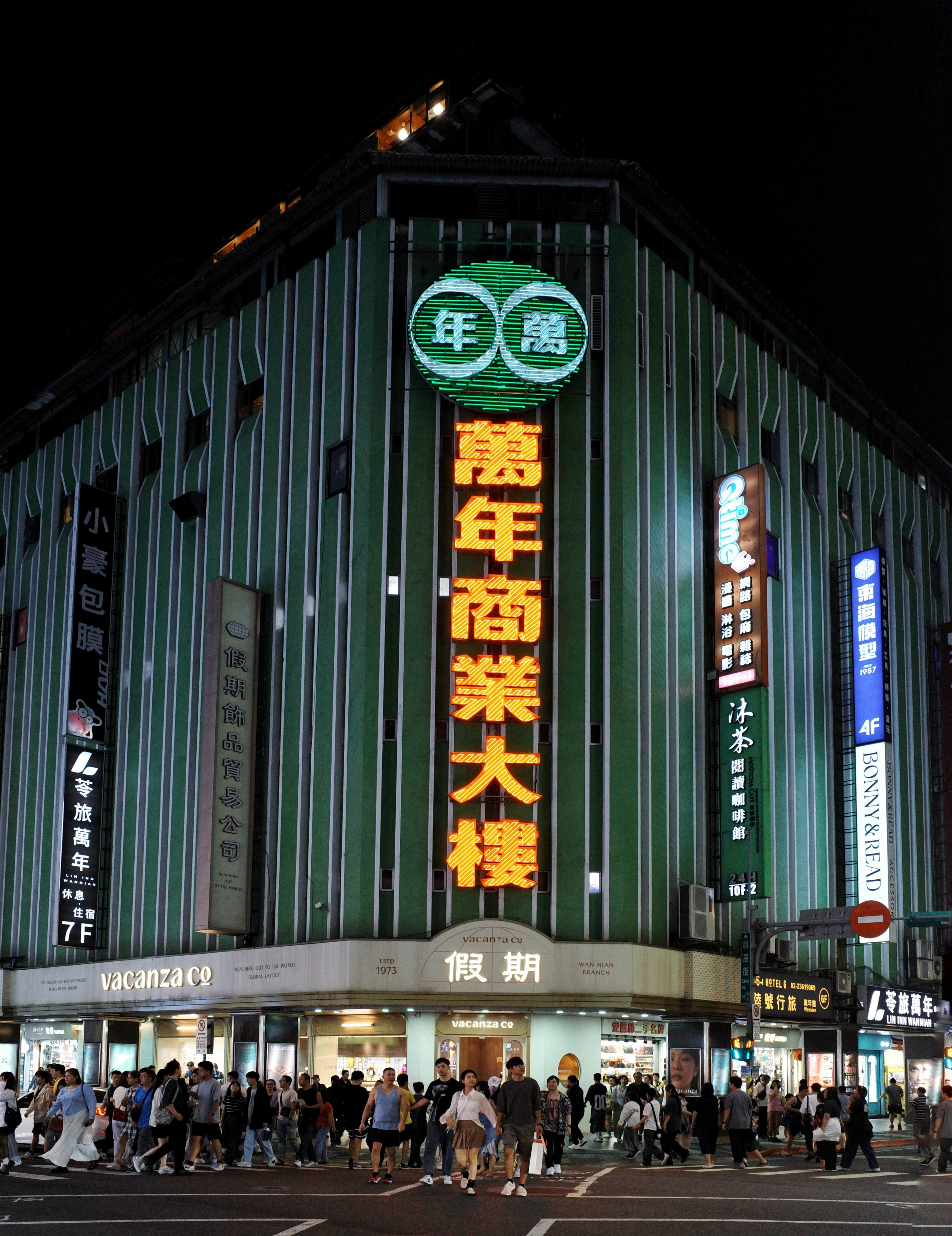萬年大樓の外観と西門町の賑わう夜の街並み