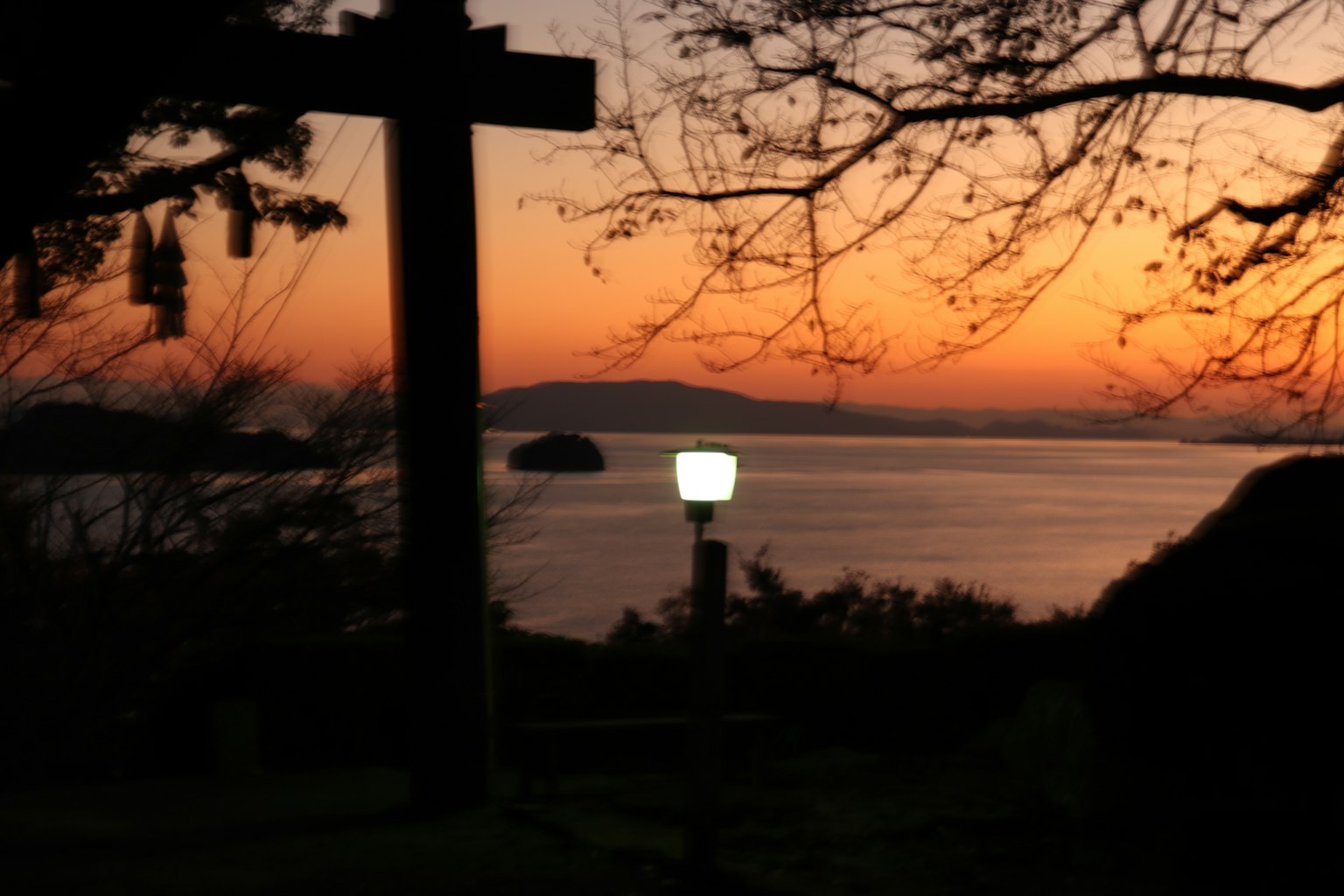Silhouette di un lampione contro un tramonto sul mare