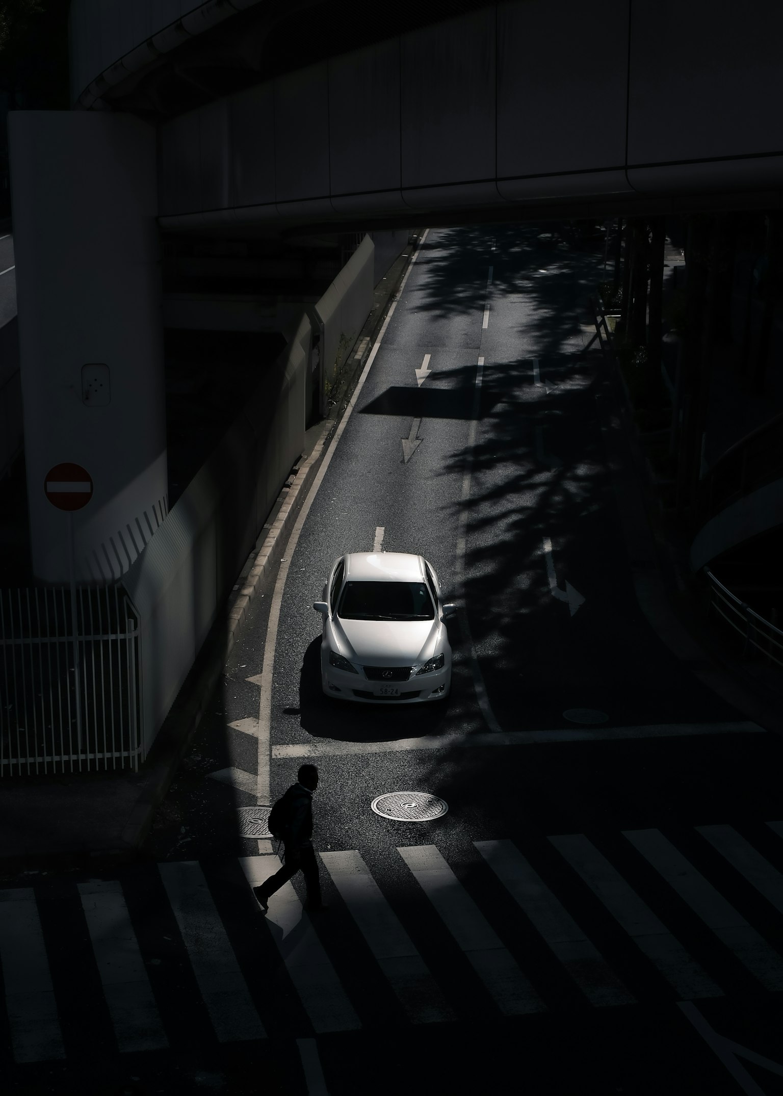 Mobil putih di jalan gelap dengan pejalan kaki menyeberang