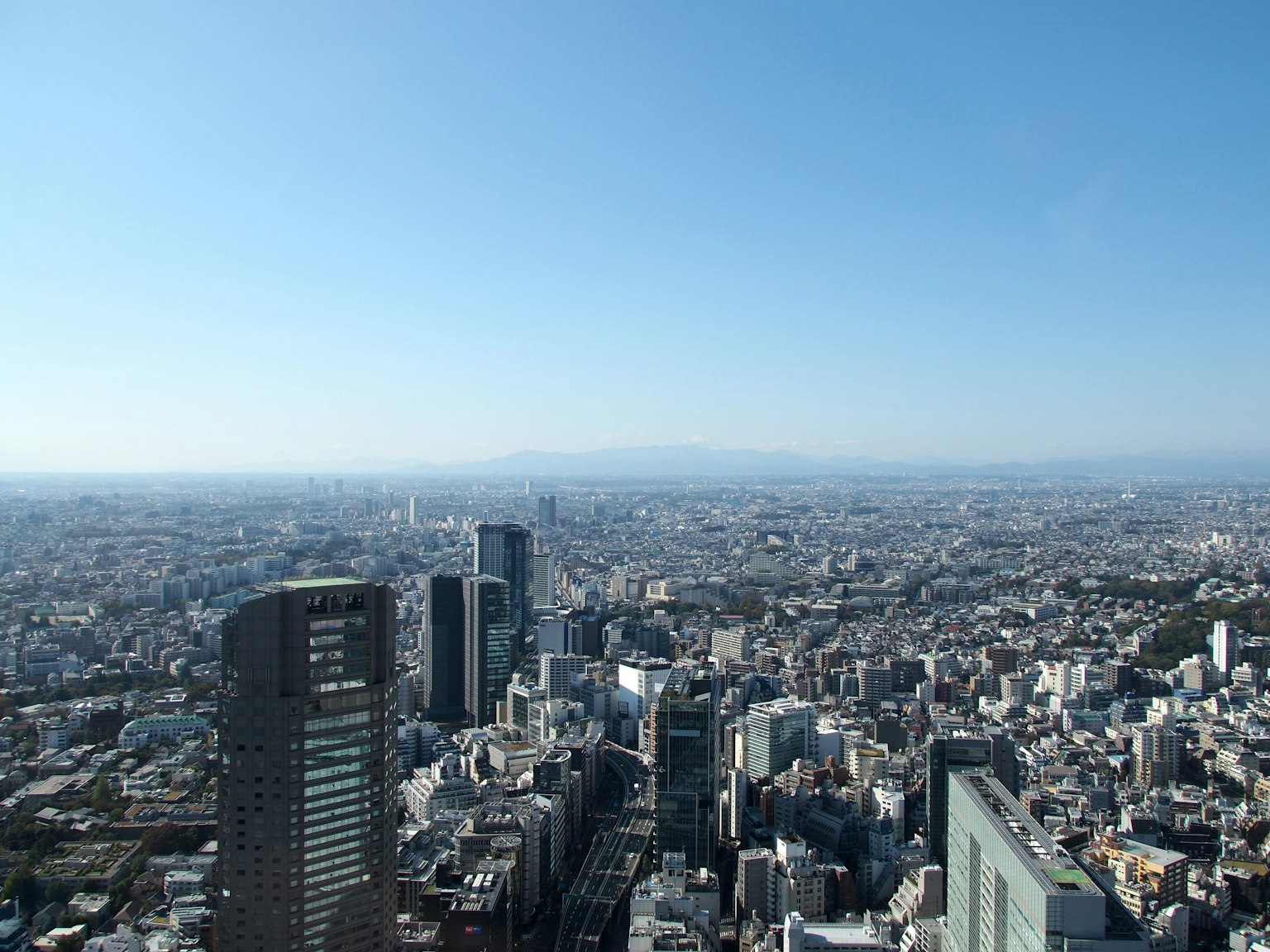 Vue panoramique d'une ville sous un ciel bleu avec des gratte-ciels et des zones résidentielles