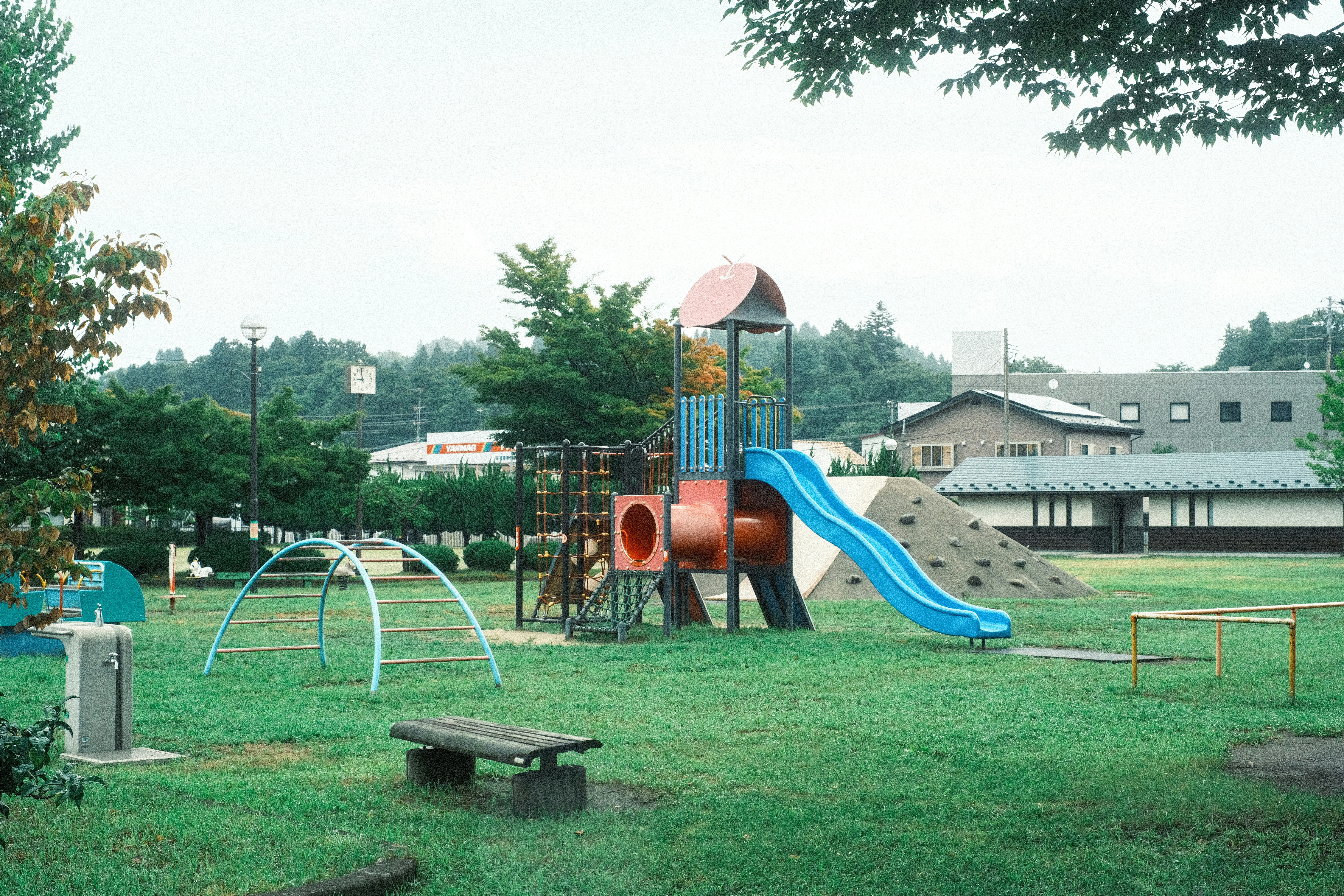 公園の芝生にある遊具と滑り台のある遊び場
