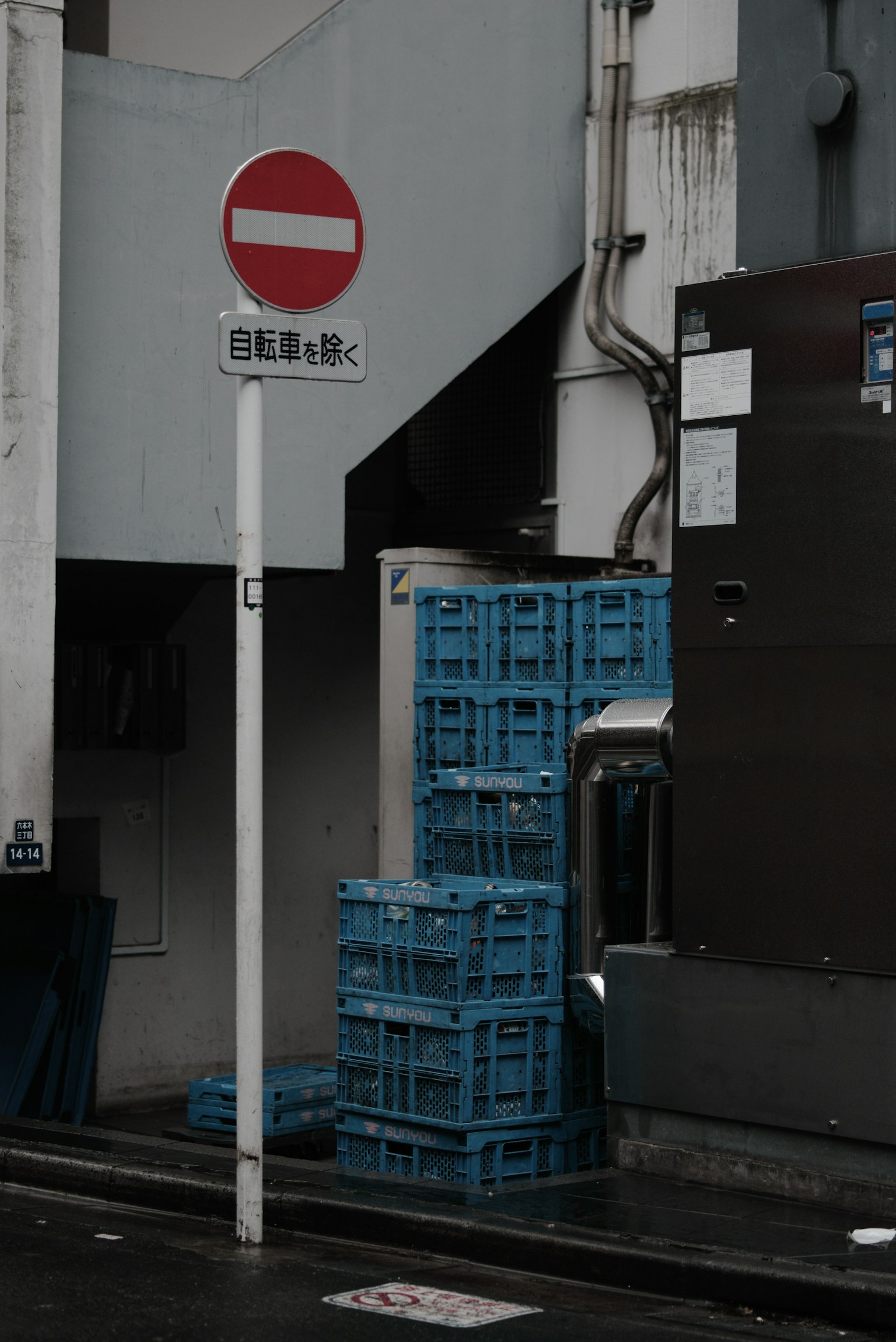 城市環境中堆放的藍色塑膠箱旁的紅色禁止標誌