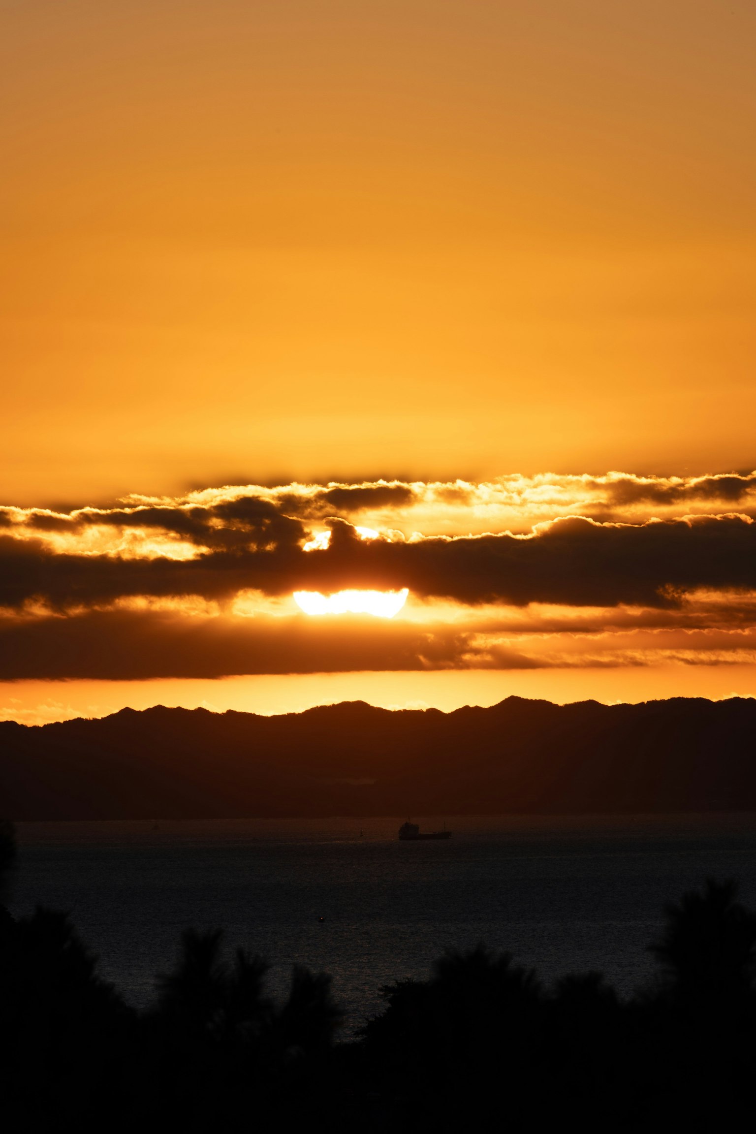 Magnifique coucher de soleil sur l'océan avec des montagnes en silhouette à l'arrière-plan