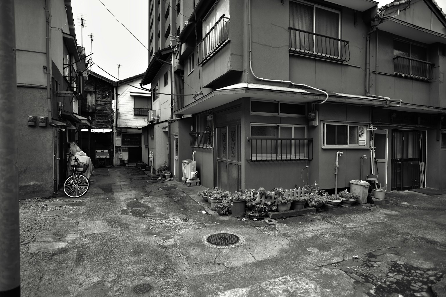 Narrow alleyway in an old residential area captured in black and white