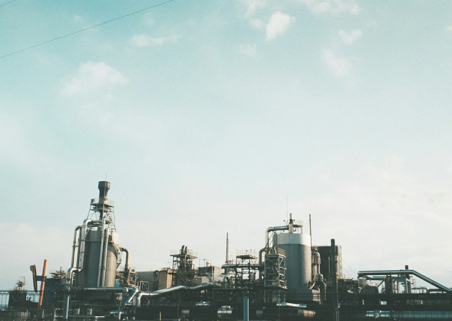 Industrial facility landscape with a clear sky and scattered clouds