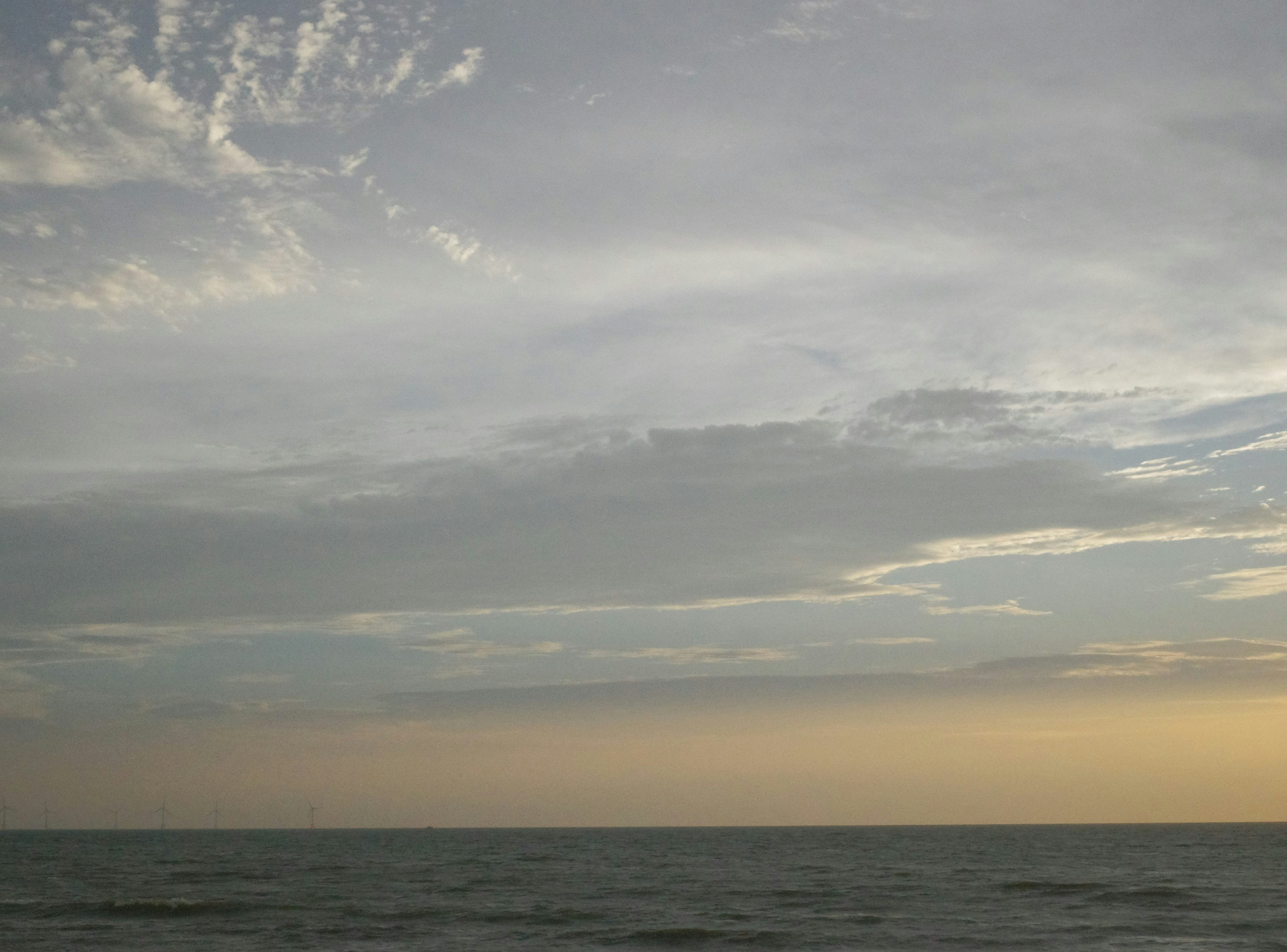 夕暮れの海に広がる雲と水平線