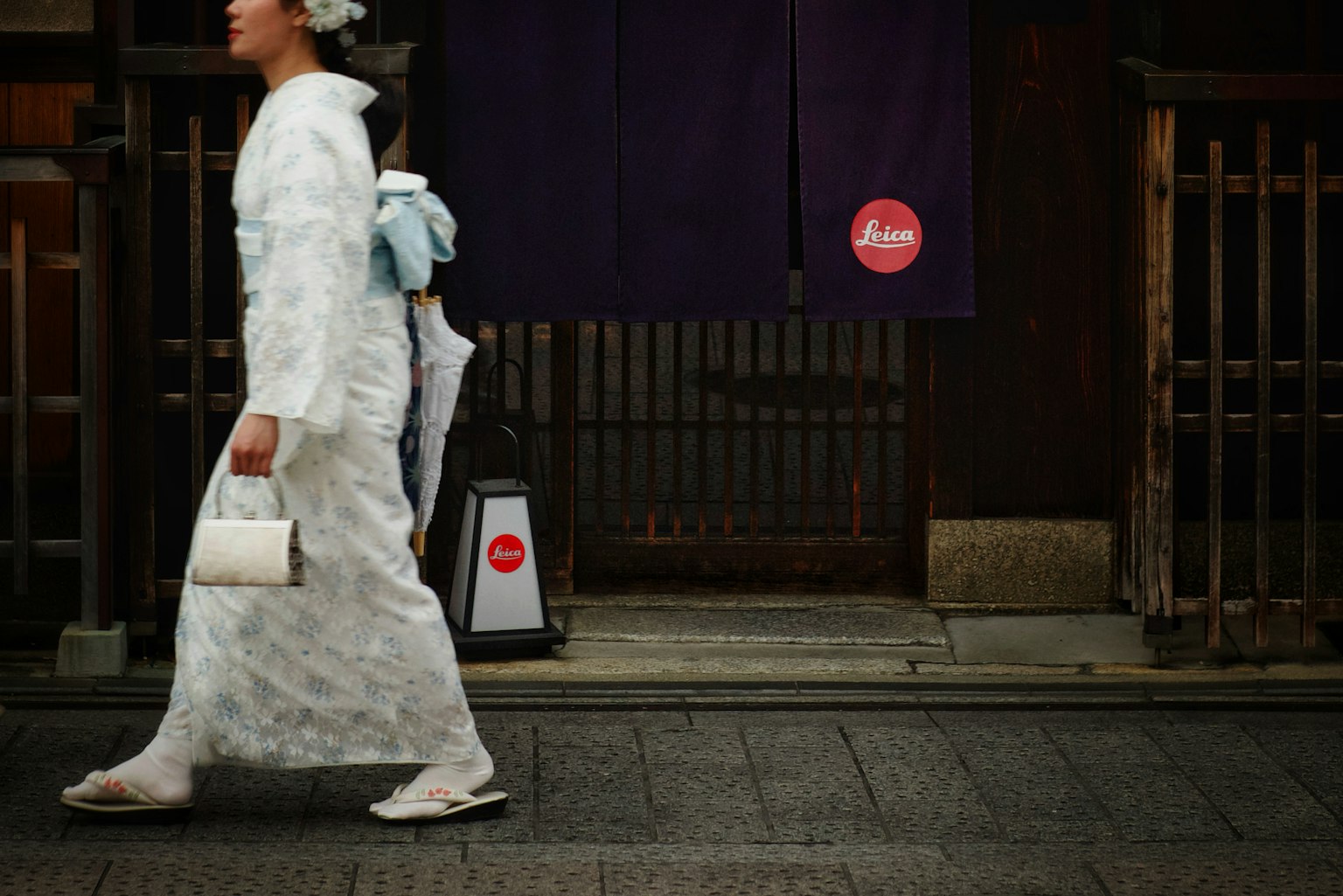 一位穿着白色和服的女性在城市街道上行走