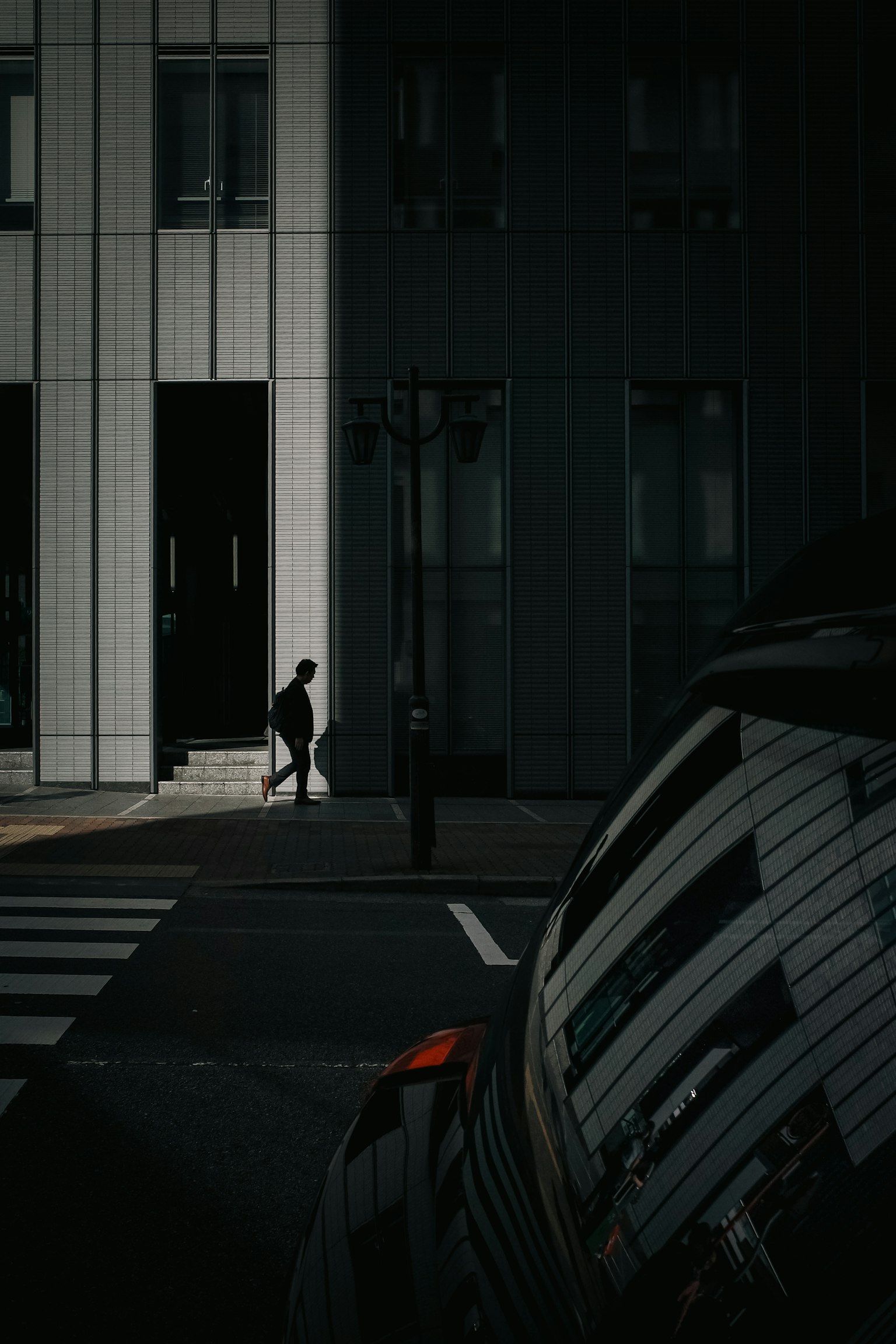 在黑暗城市環境中行走的人影與汽車反射