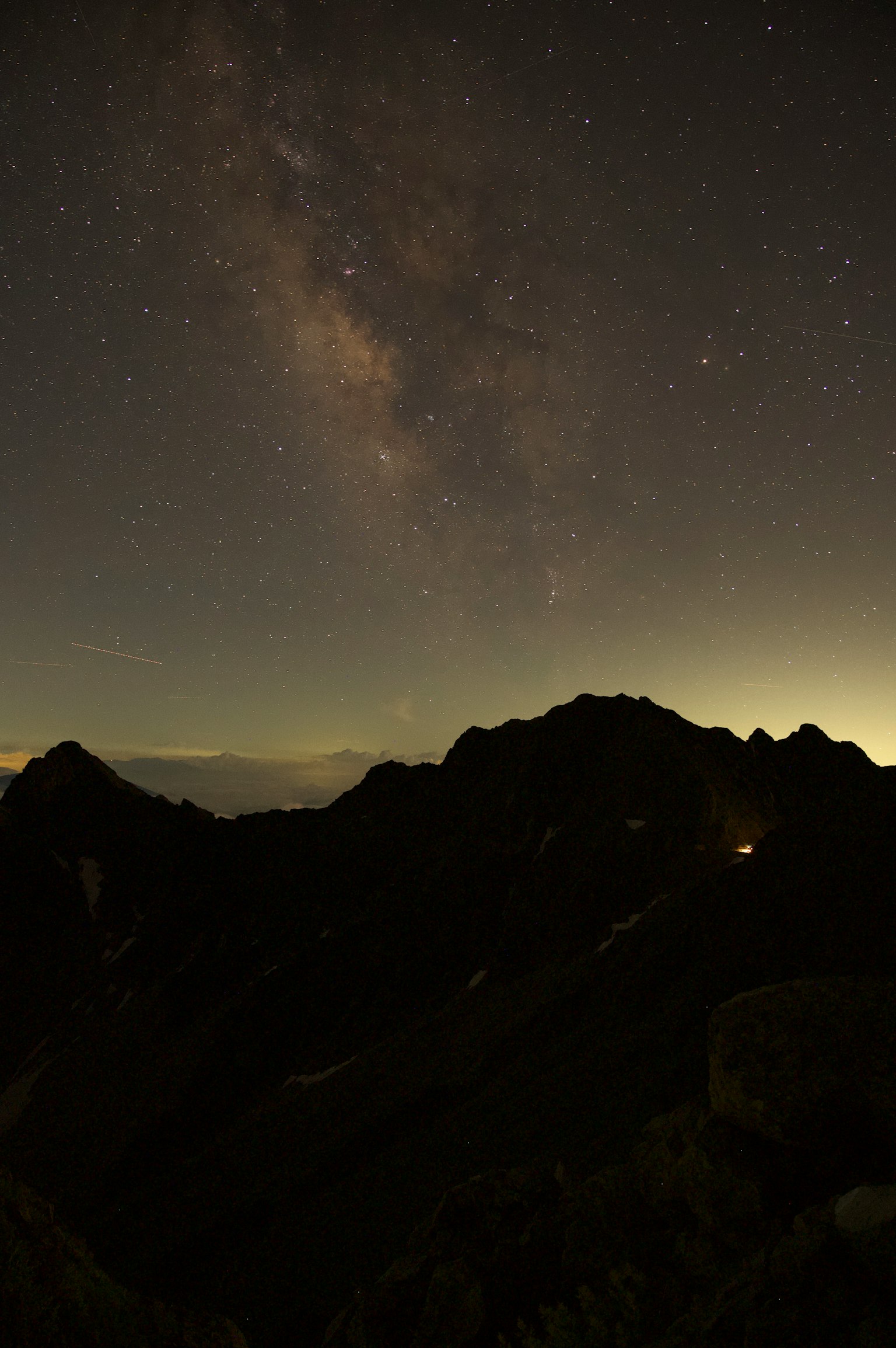 Montagne silhouette sotto un cielo stellato con una vista mozzafiato della Via Lattea