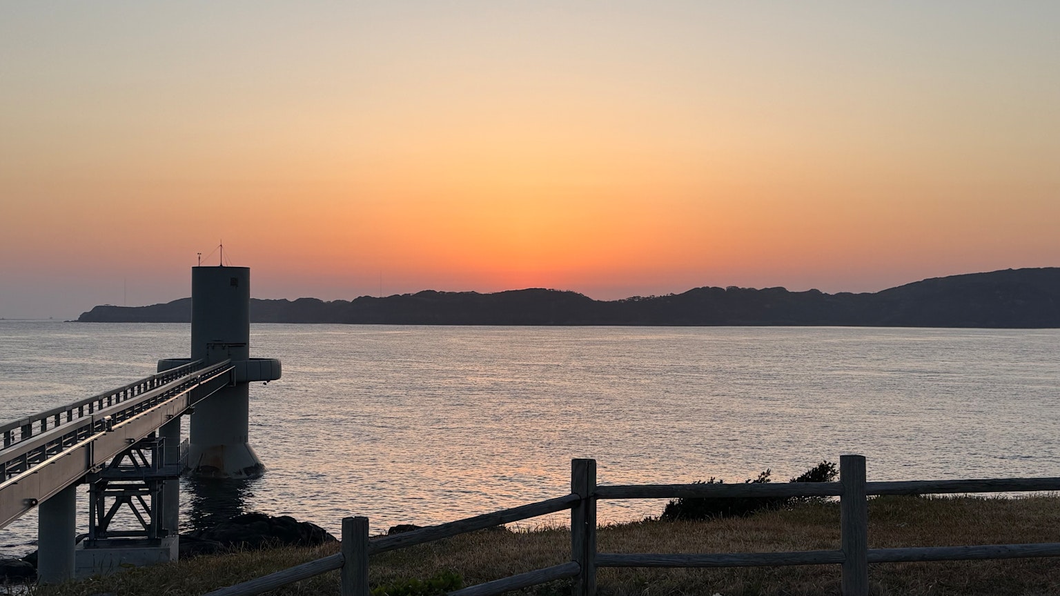 平静的海面和日落景色带有码头