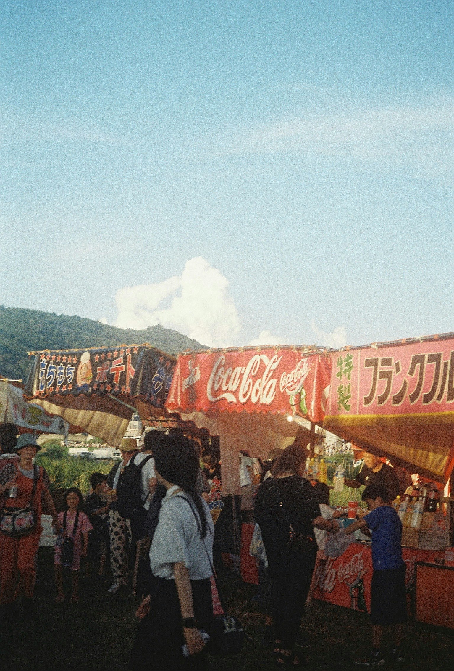 Via commerciale al crepuscolo con bancarelle di festival estivo