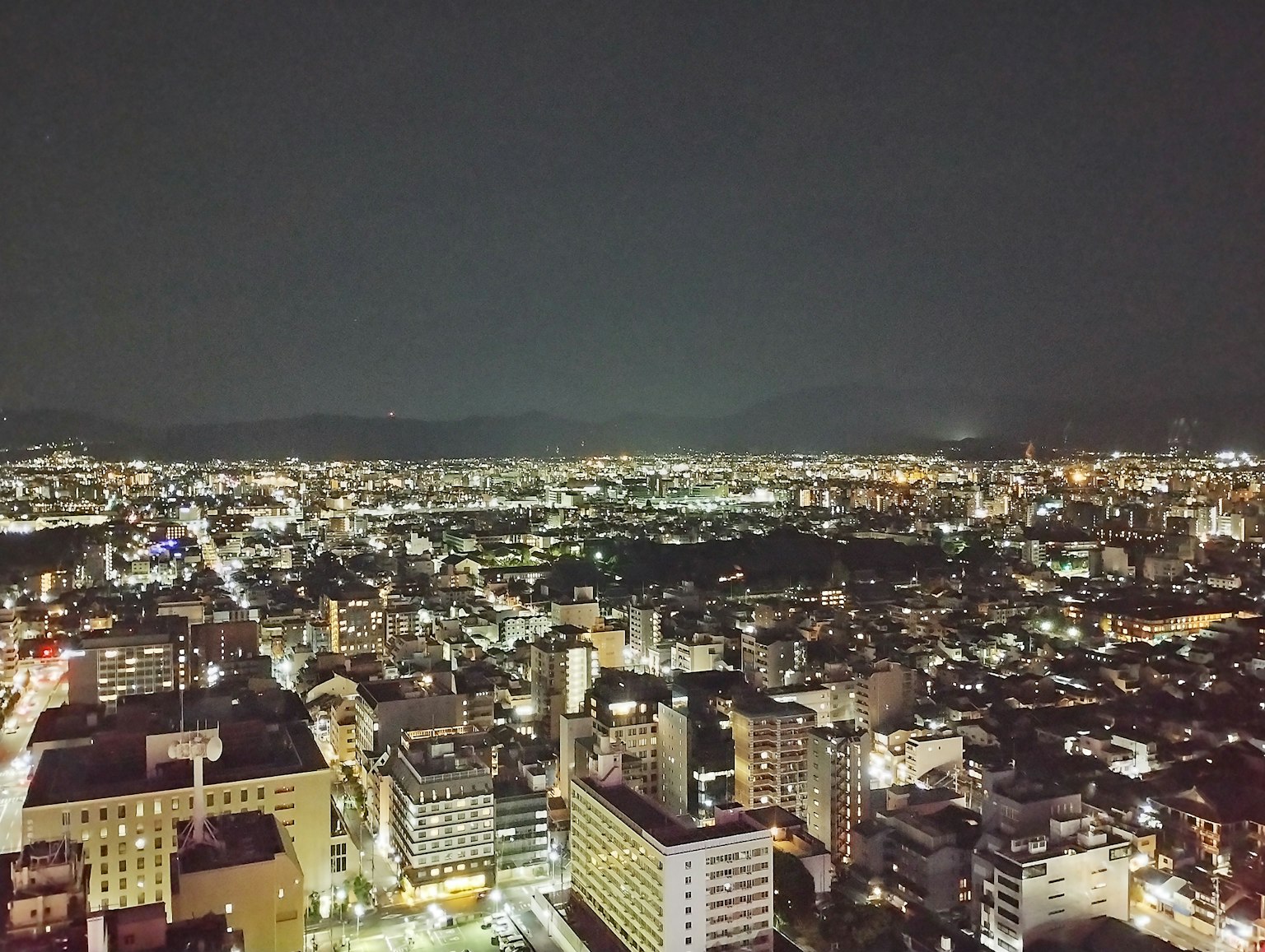 Paisaje urbano nocturno con edificios iluminados y luces