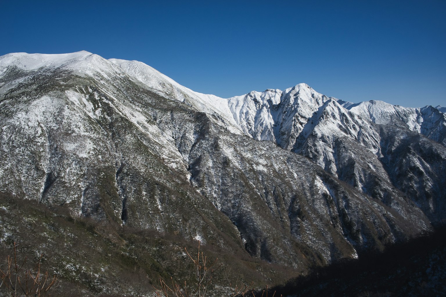 푸른 하늘 아래 눈 덮인 산 풍경