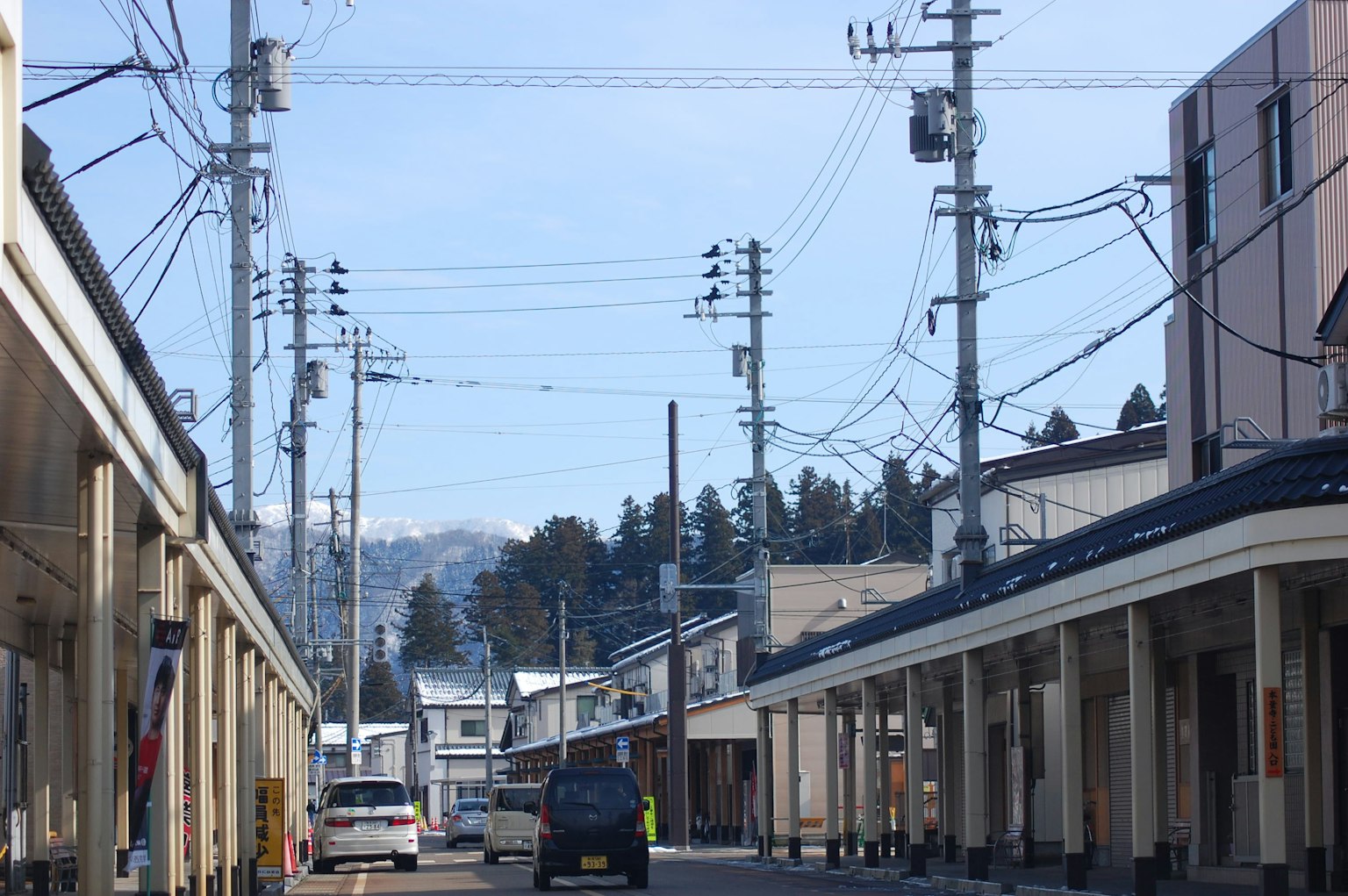 Ruhige Straße unter blauem Himmel mit Stromleitungen und fernen Bergen