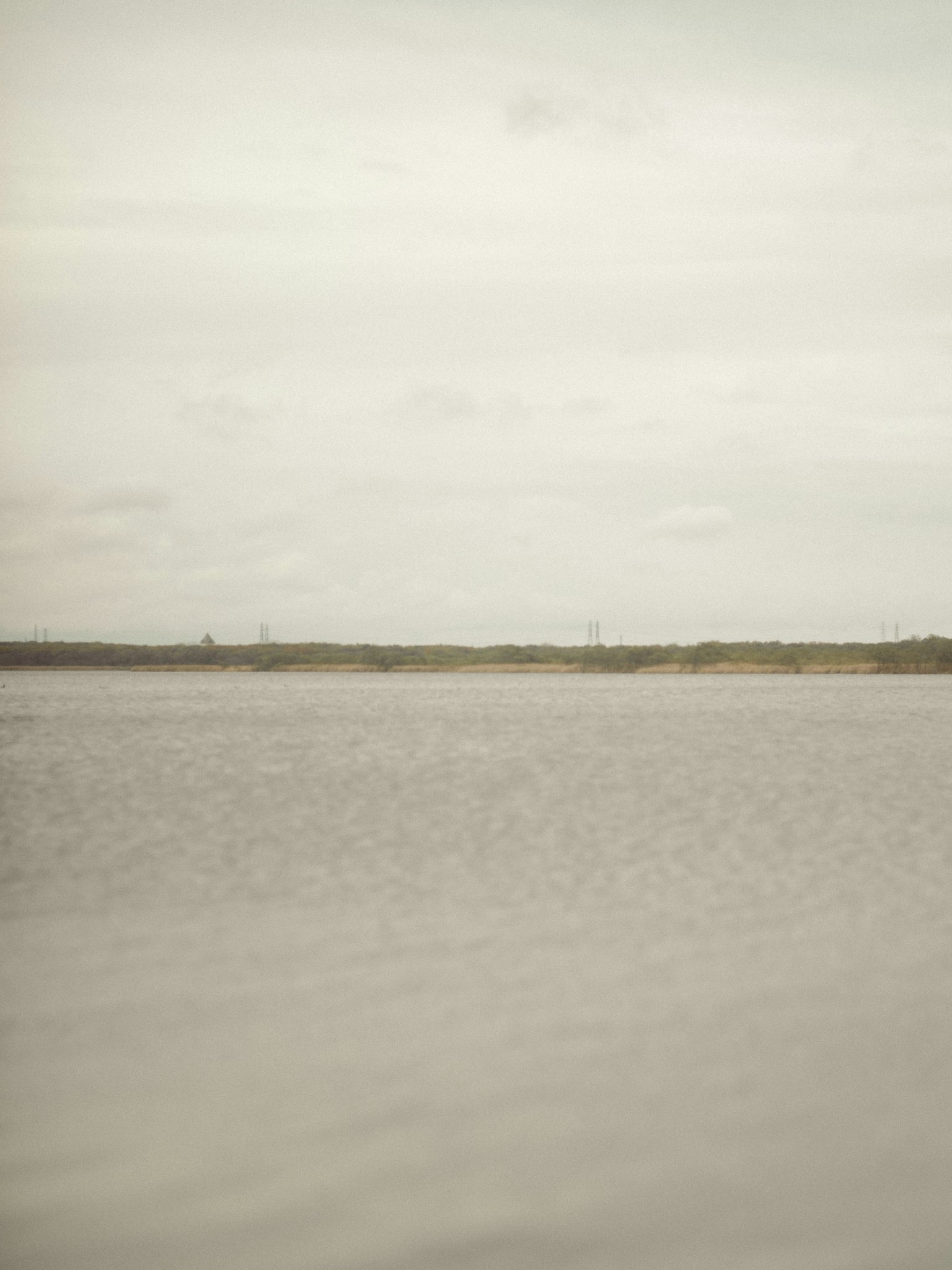 Calm water surface with an overcast sky