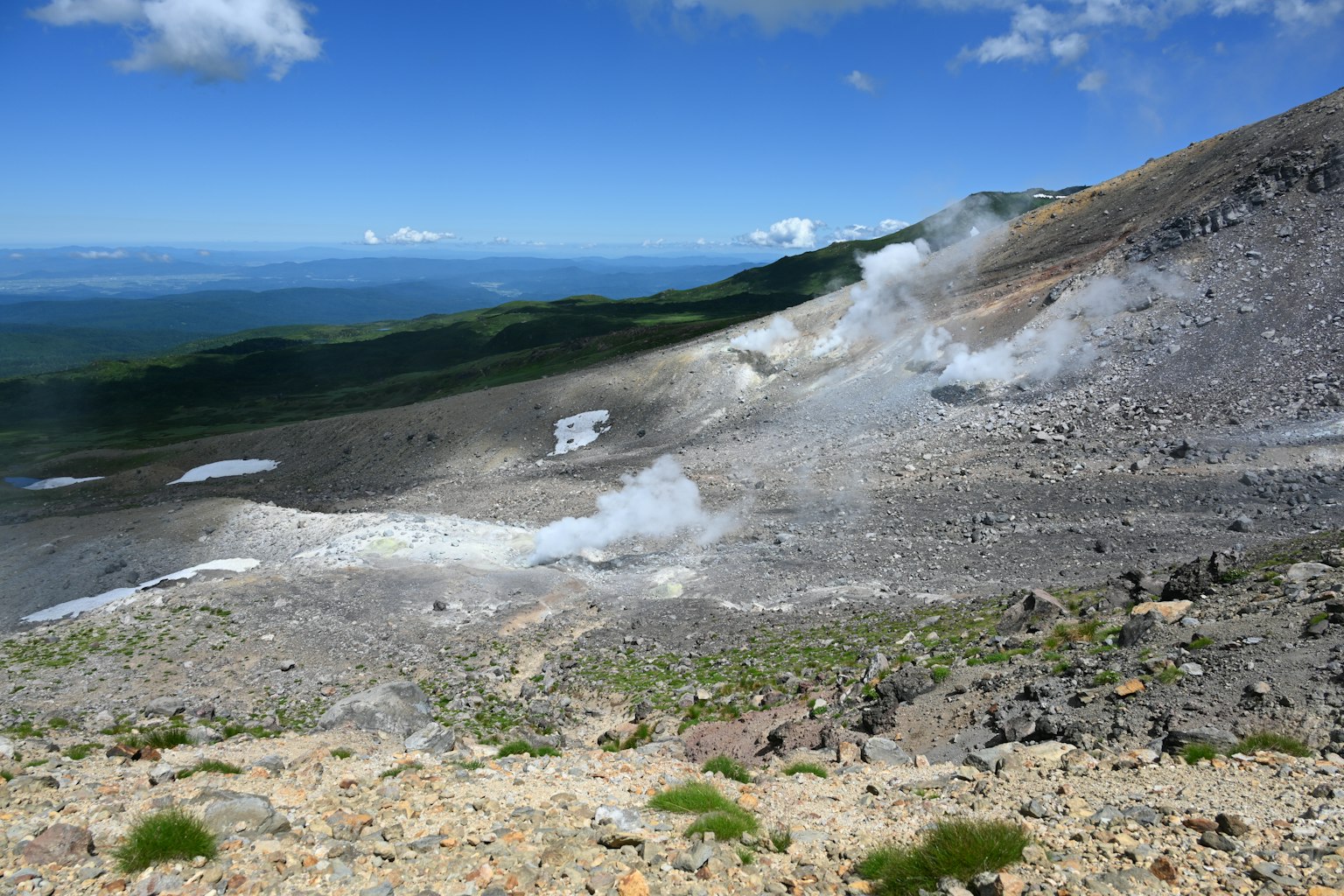 Vulkanische Hänge mit Rauch und felsiger Landschaft