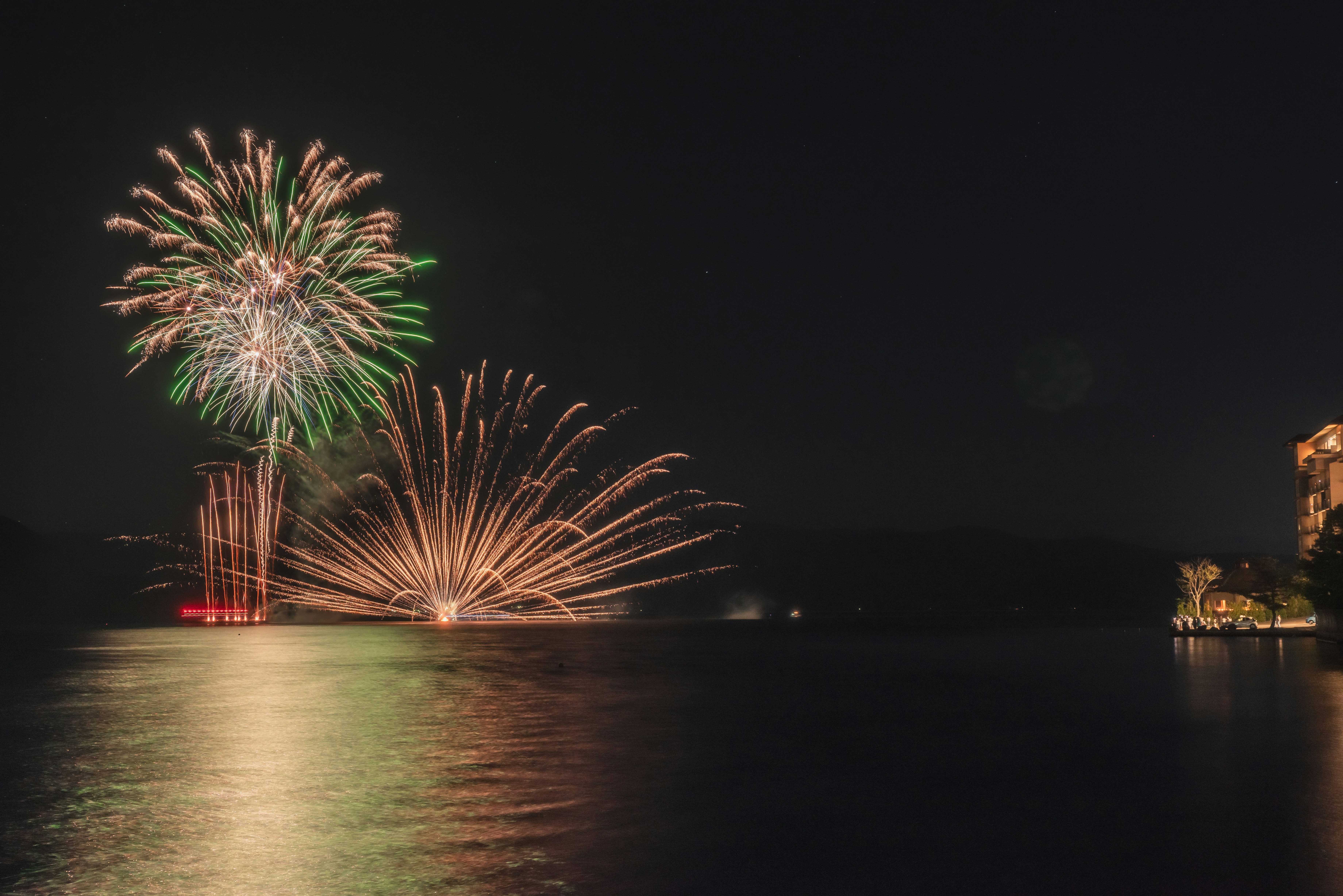 洞爺湖の湖畔で打ち上がる花火の夜景