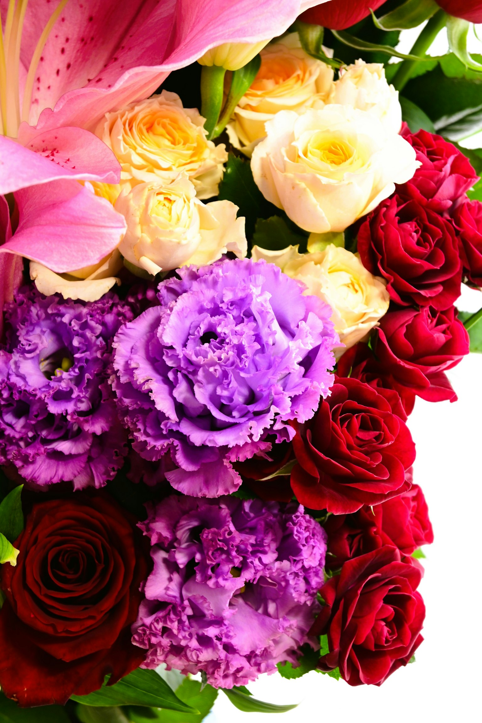 ช่อดอกไม้สดใสที่มีลิลลี่สีชมพู, กุหลาบสีครีม, ลิซิแอนธัสสีม่วง และกุหลาบสีแดง