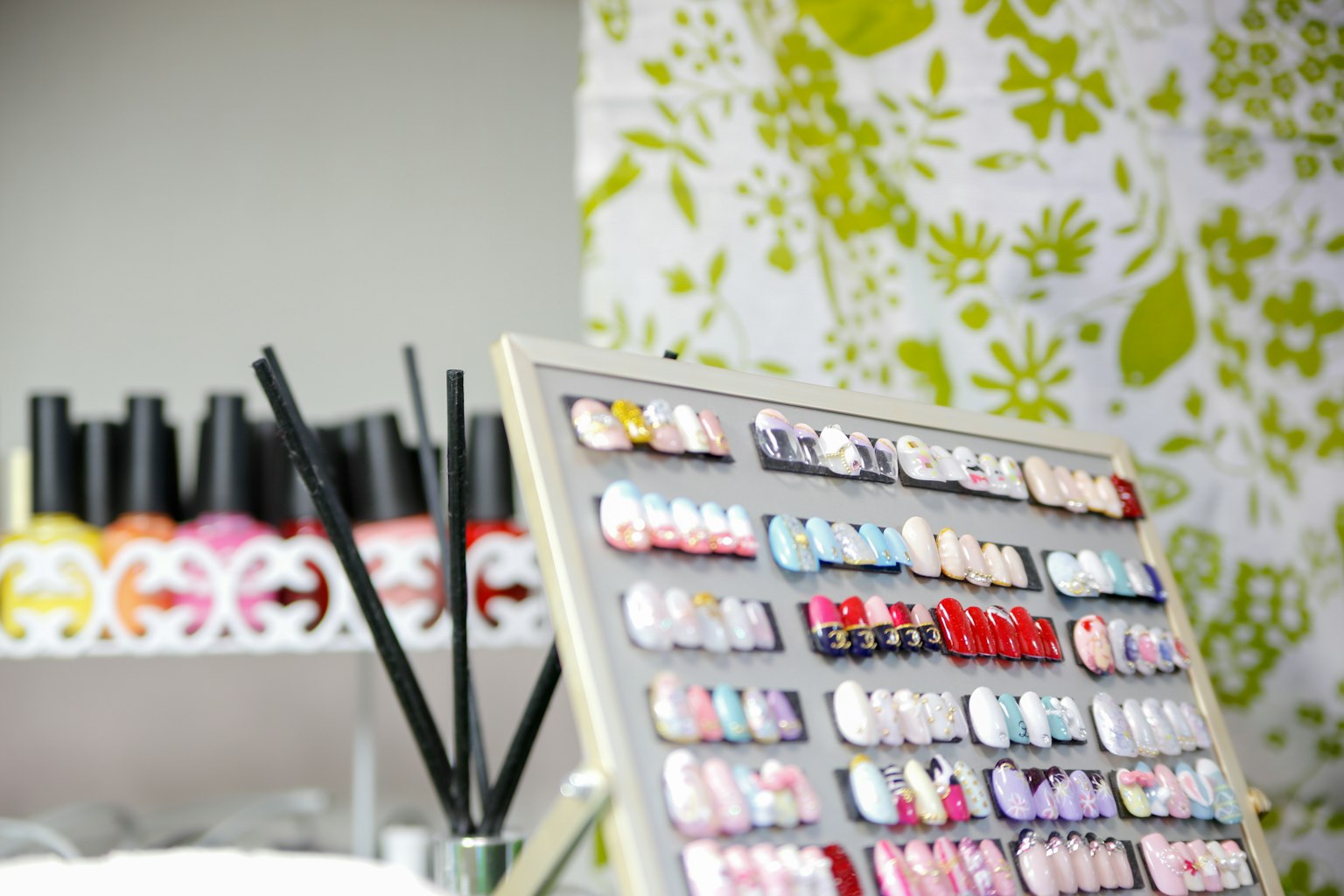 Exhibición colorida de uñas postizas en un salón de belleza con botellas de esmalte