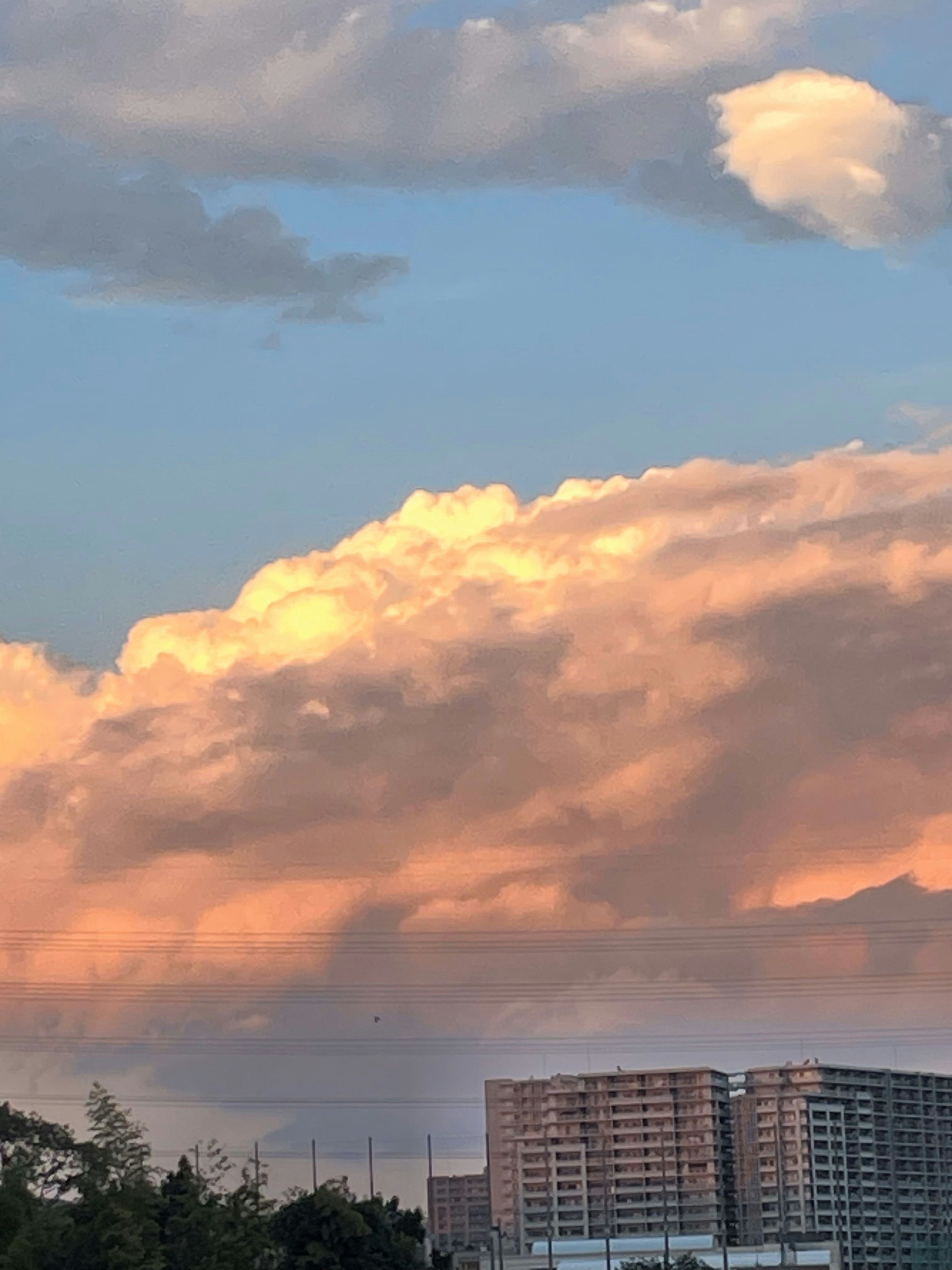 Cielo al tramonto con nuvole sopra una vista costiera lontana e torri di appartamenti