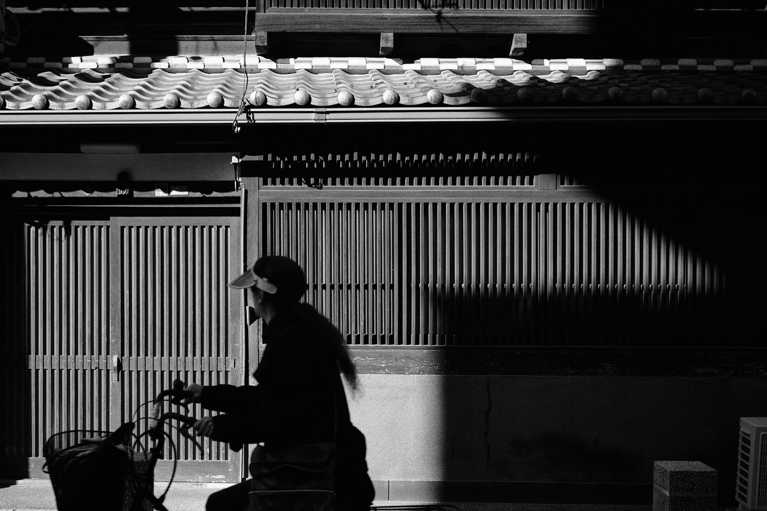 Silhouette d'une personne à vélo devant une architecture traditionnelle