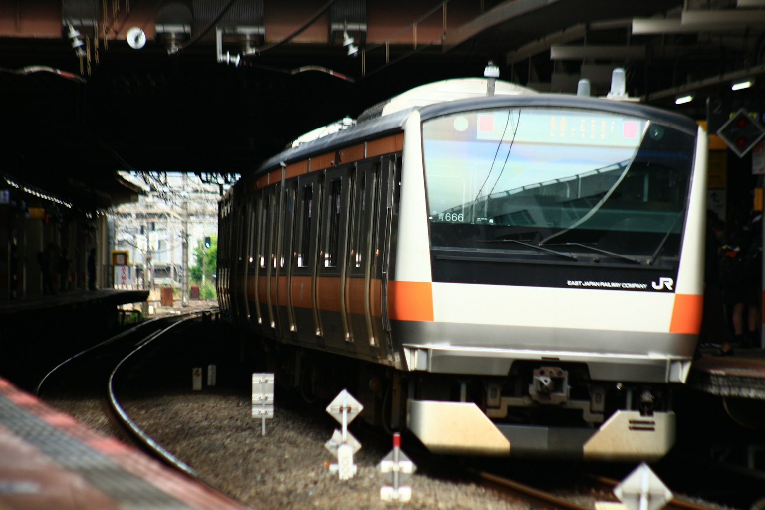 橙色和銀色火車在火車站轉彎