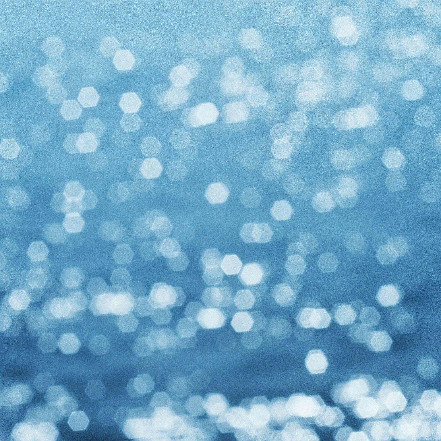Refleksi heksagonal bokeh di permukaan air biru