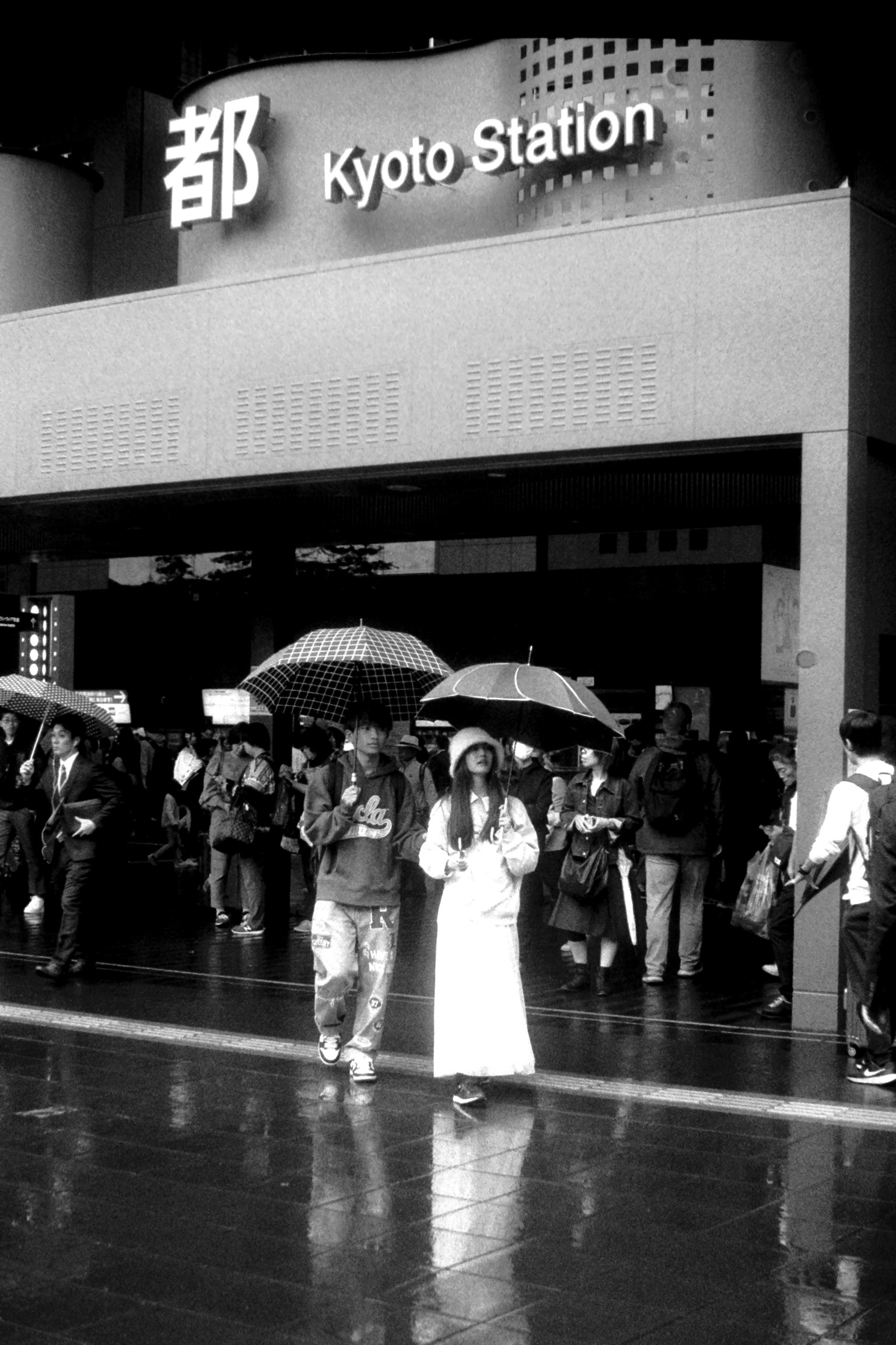 雨中在京都車站前的人們和雨傘