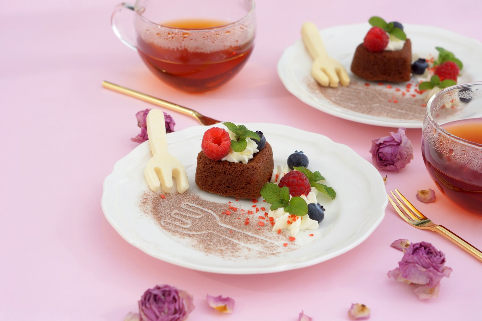 Piring dessert cokelat dengan beri dan mint di latar belakang merah muda