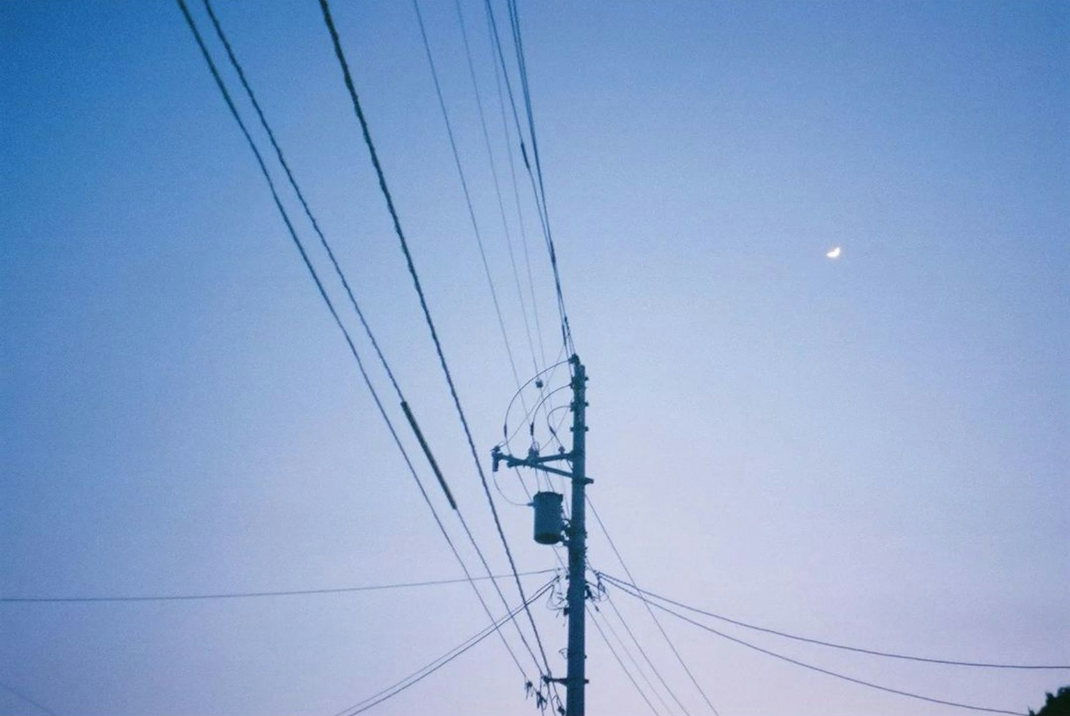 A power pole and wires against a blue sky