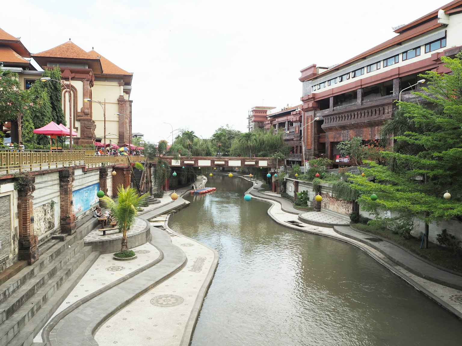 Cảnh quan của một con sông ở Bali với các tòa nhà hiện đại và cây xanh tươi tốt