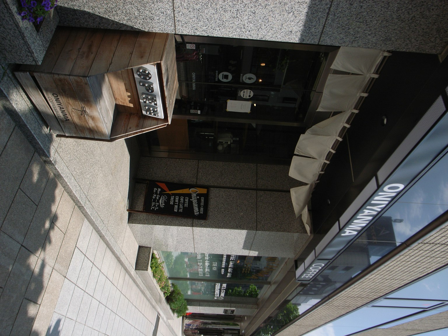 Photo of a building entrance featuring a wooden sign and a black door