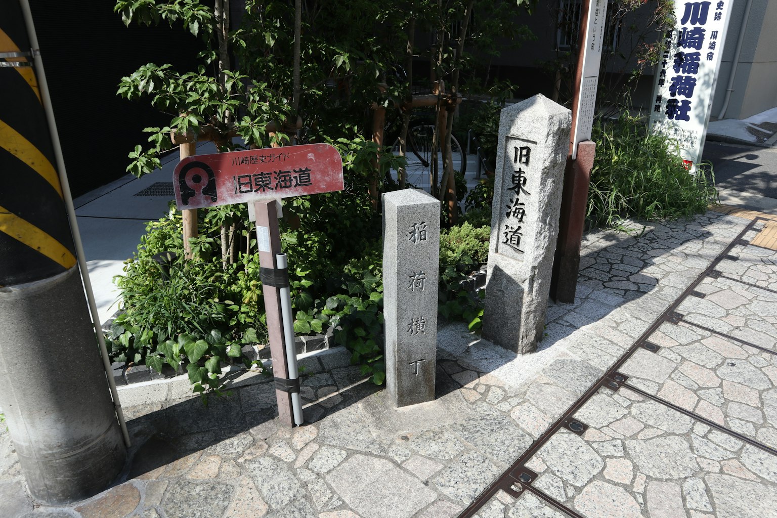 街景中有标志和石柱被绿植环绕