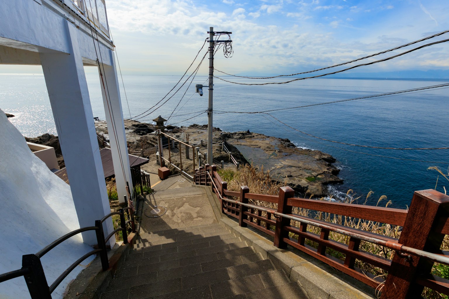 Treppe, die zum Meer führen, mit Blick auf Stromleitungen