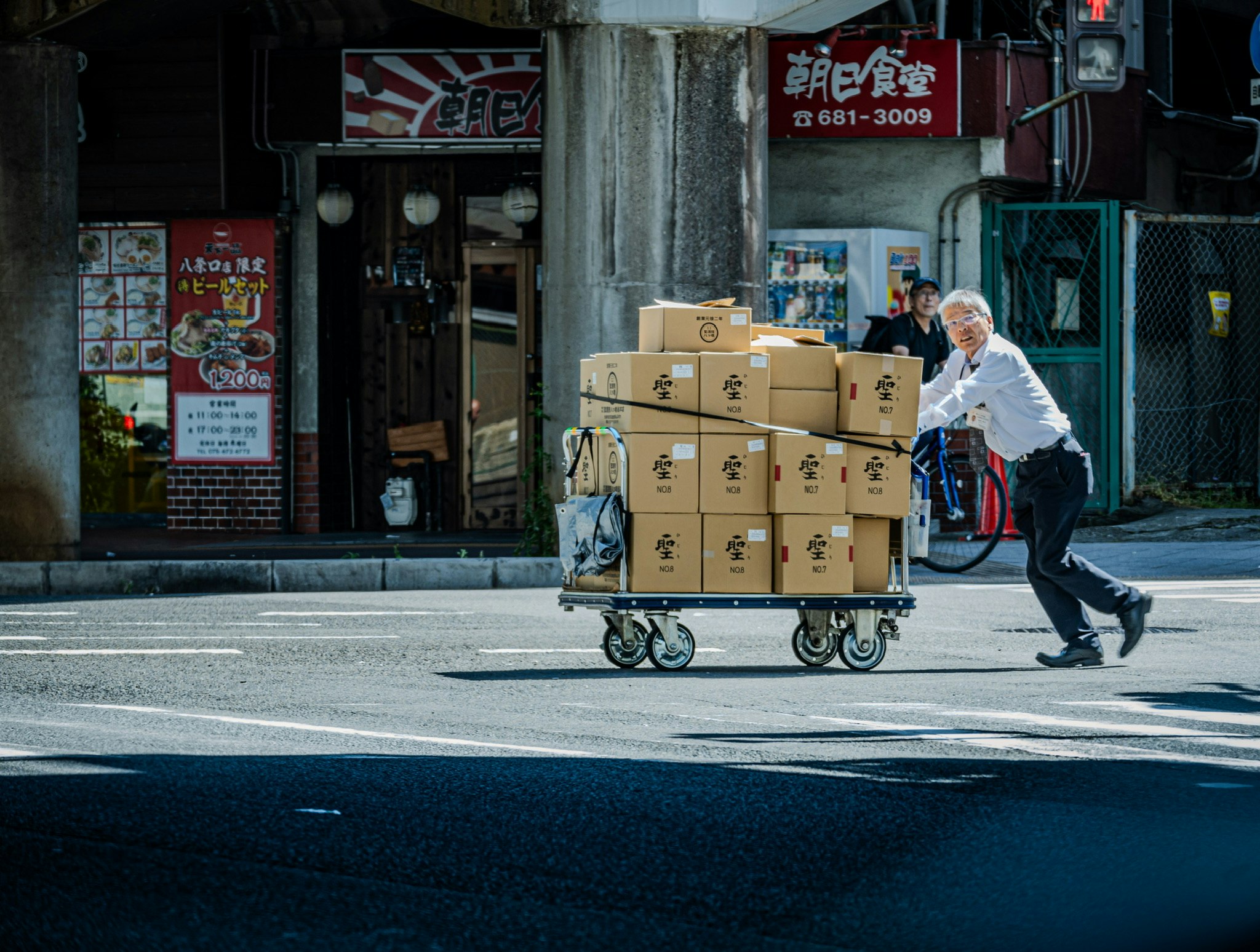 推著裝滿紙箱的手推車的外送員在街上