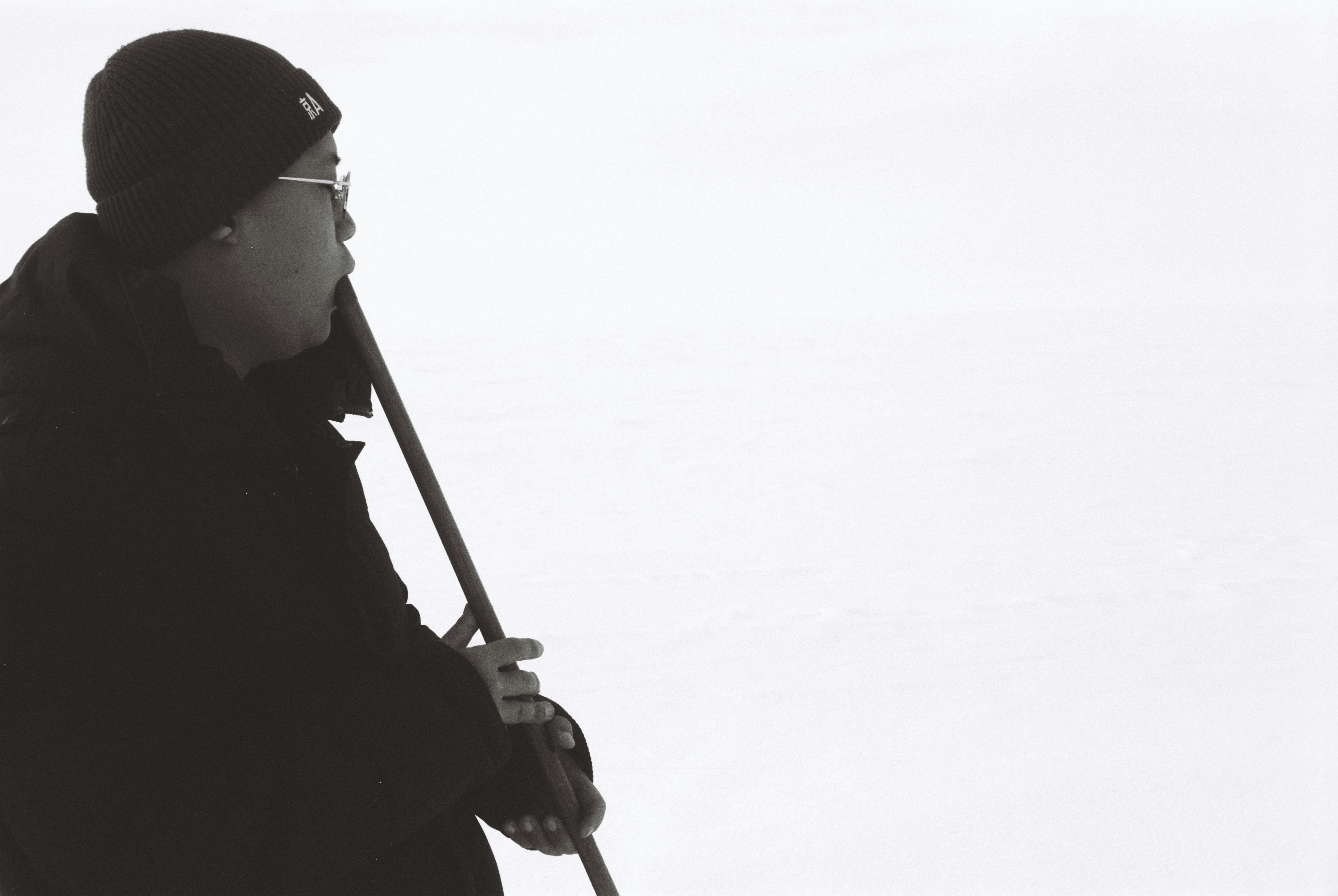 黒いコートの人物が杖を持つシルエット