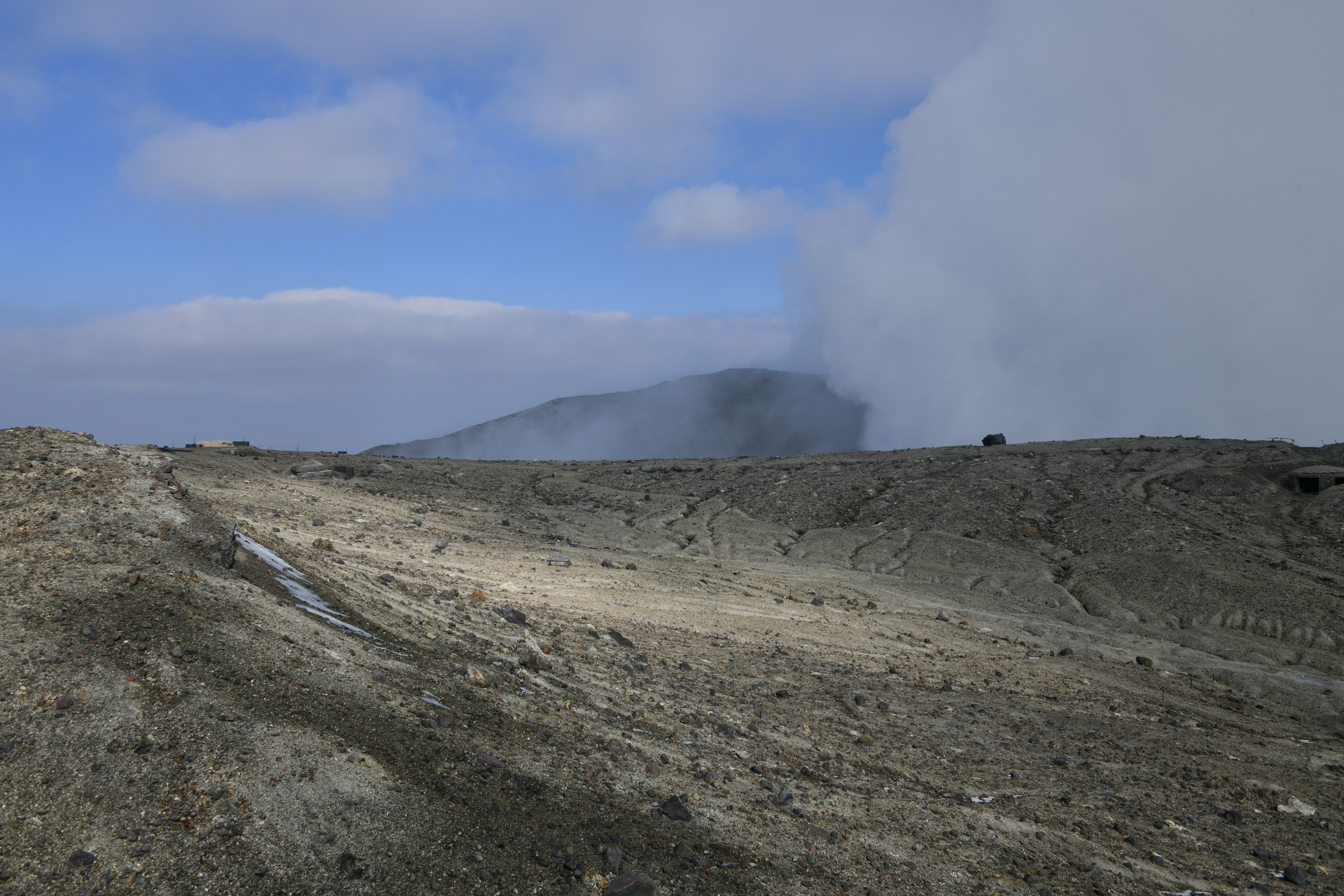 冒着蒸汽的火山坡与远处山脉