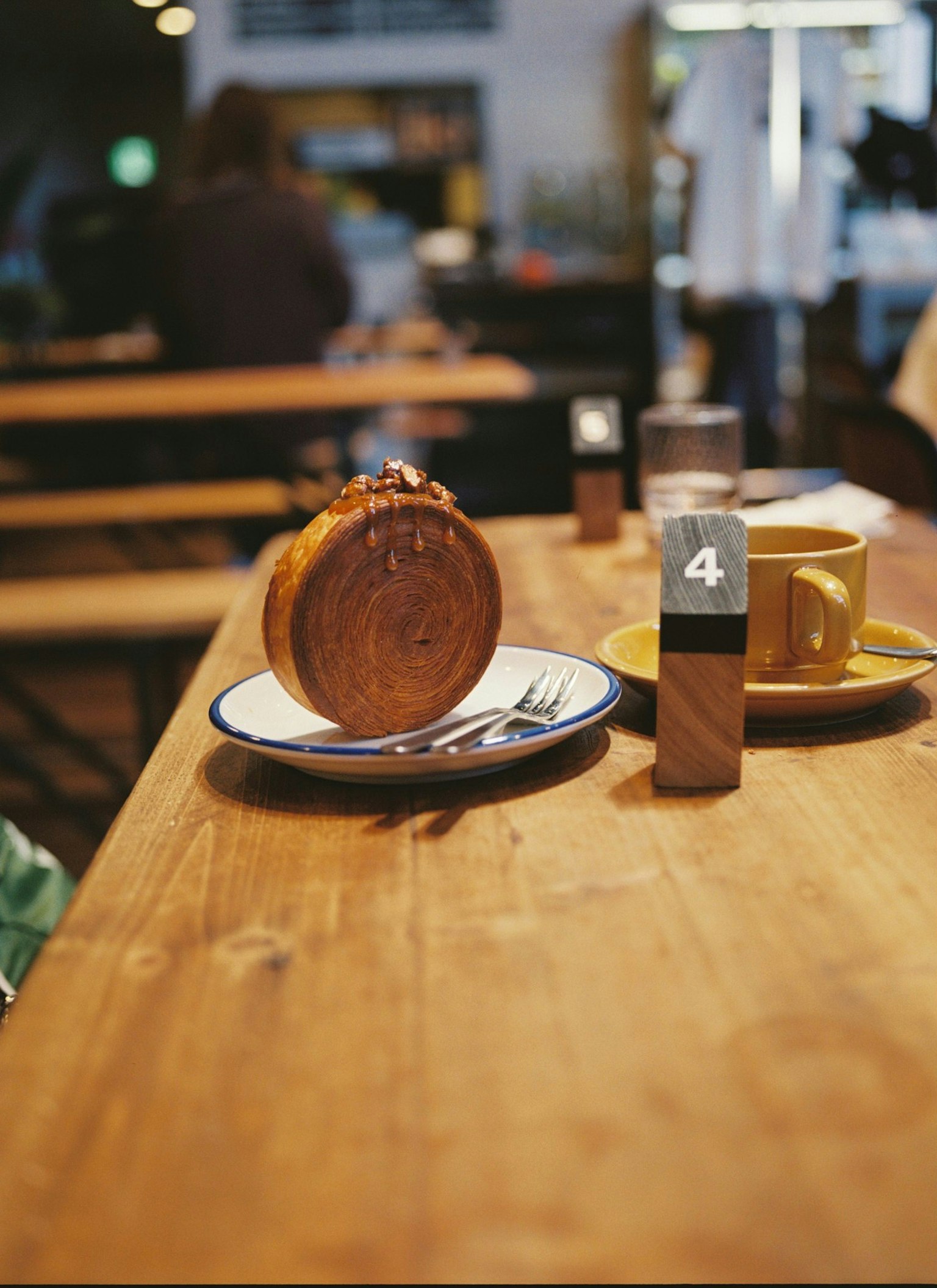 Une table en bois avec une tasse de café et une assiette de dessert