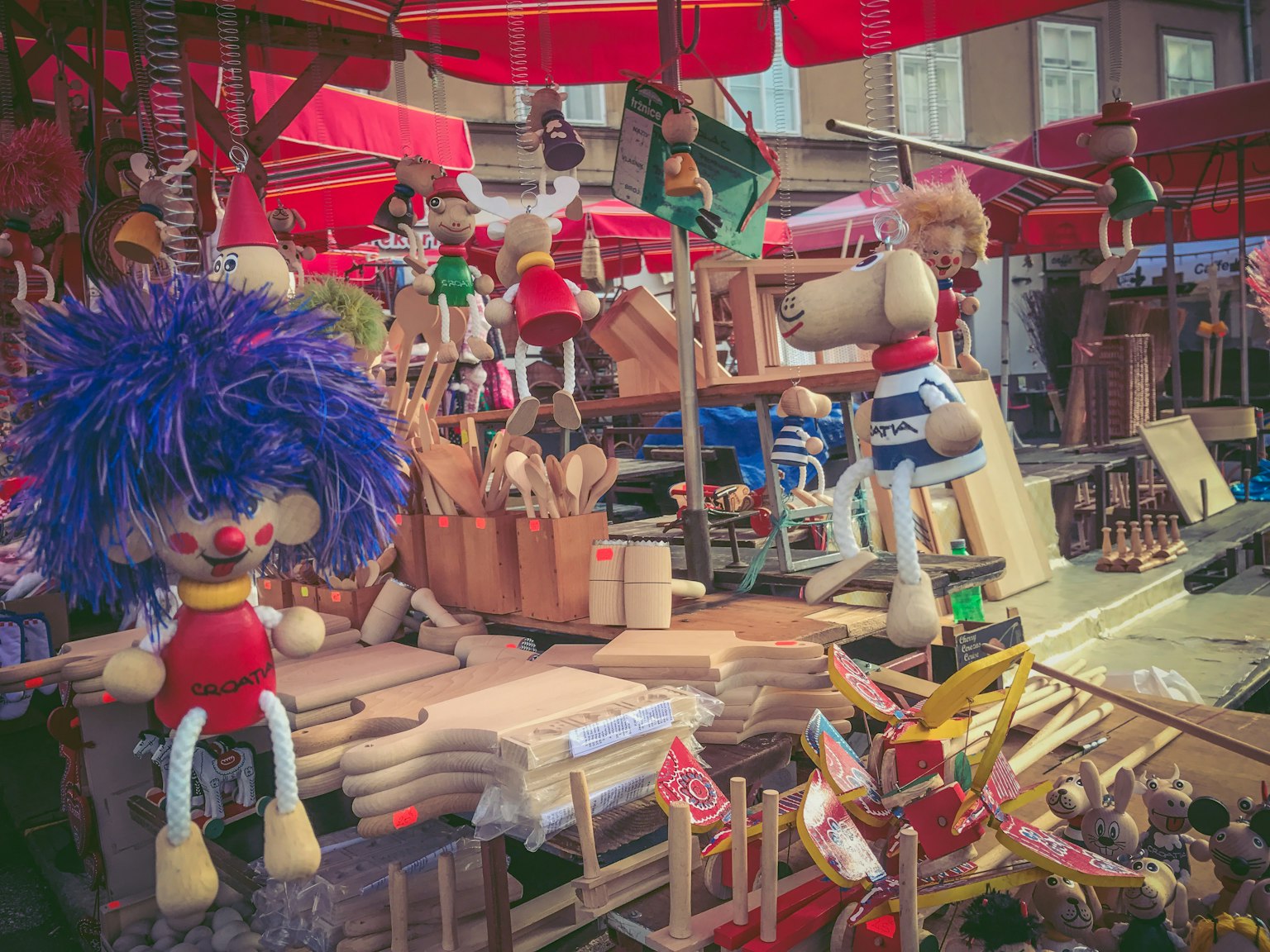 Muñecos coloridos y juguetes de madera exhibidos en una escena de mercado vibrante