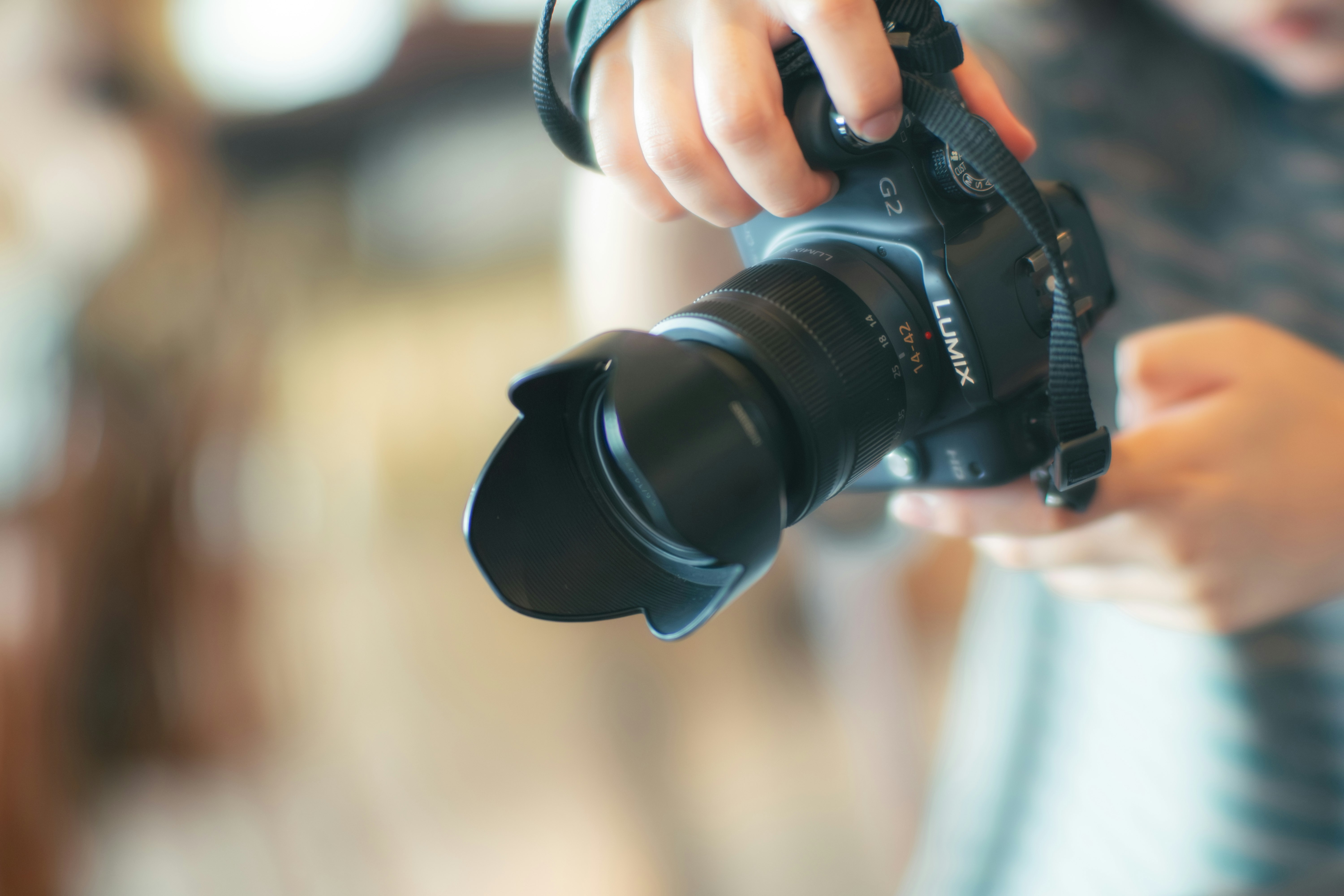 a person holding a camera with a prominent lens