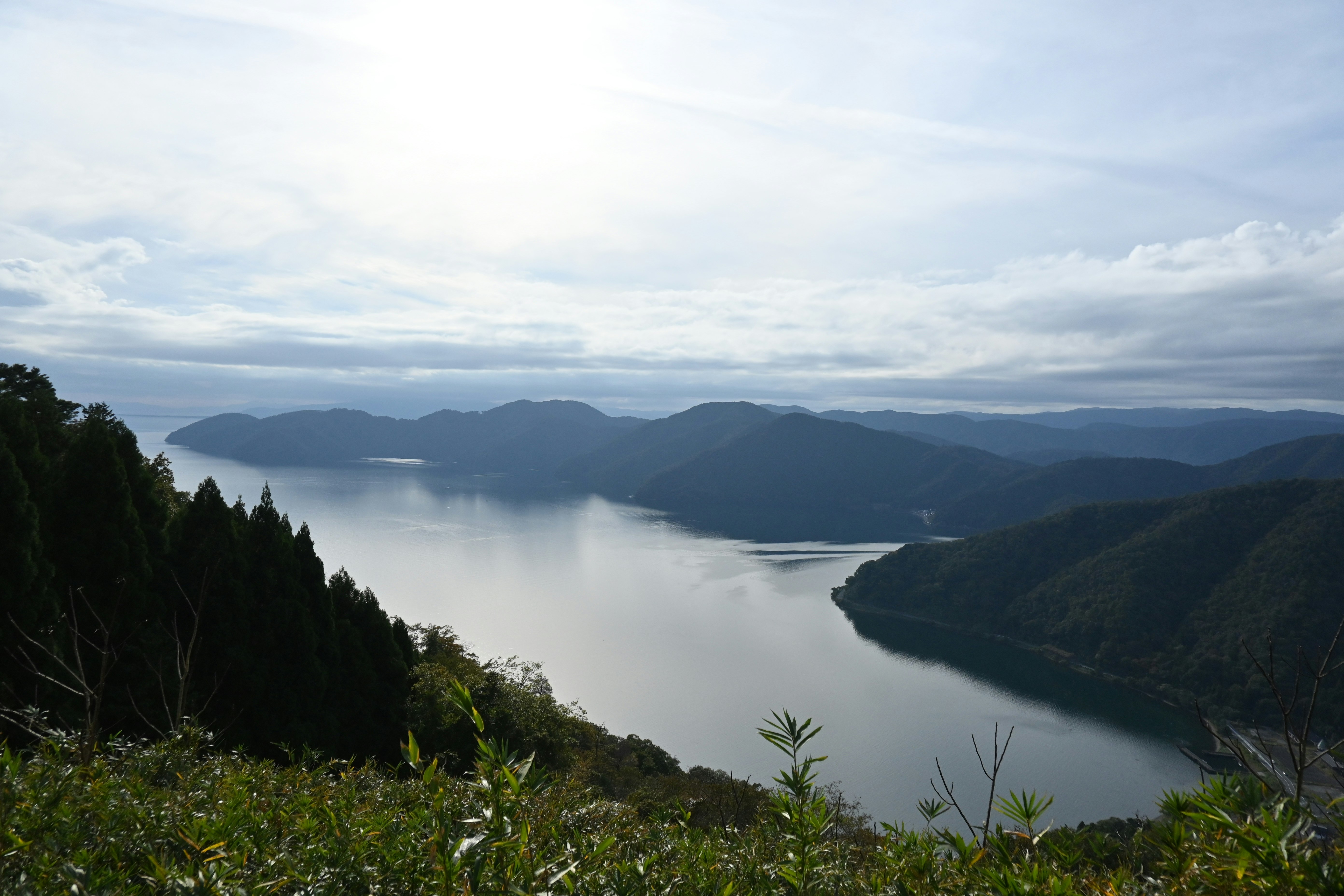 霧に包まれた湖と山並みの絶景