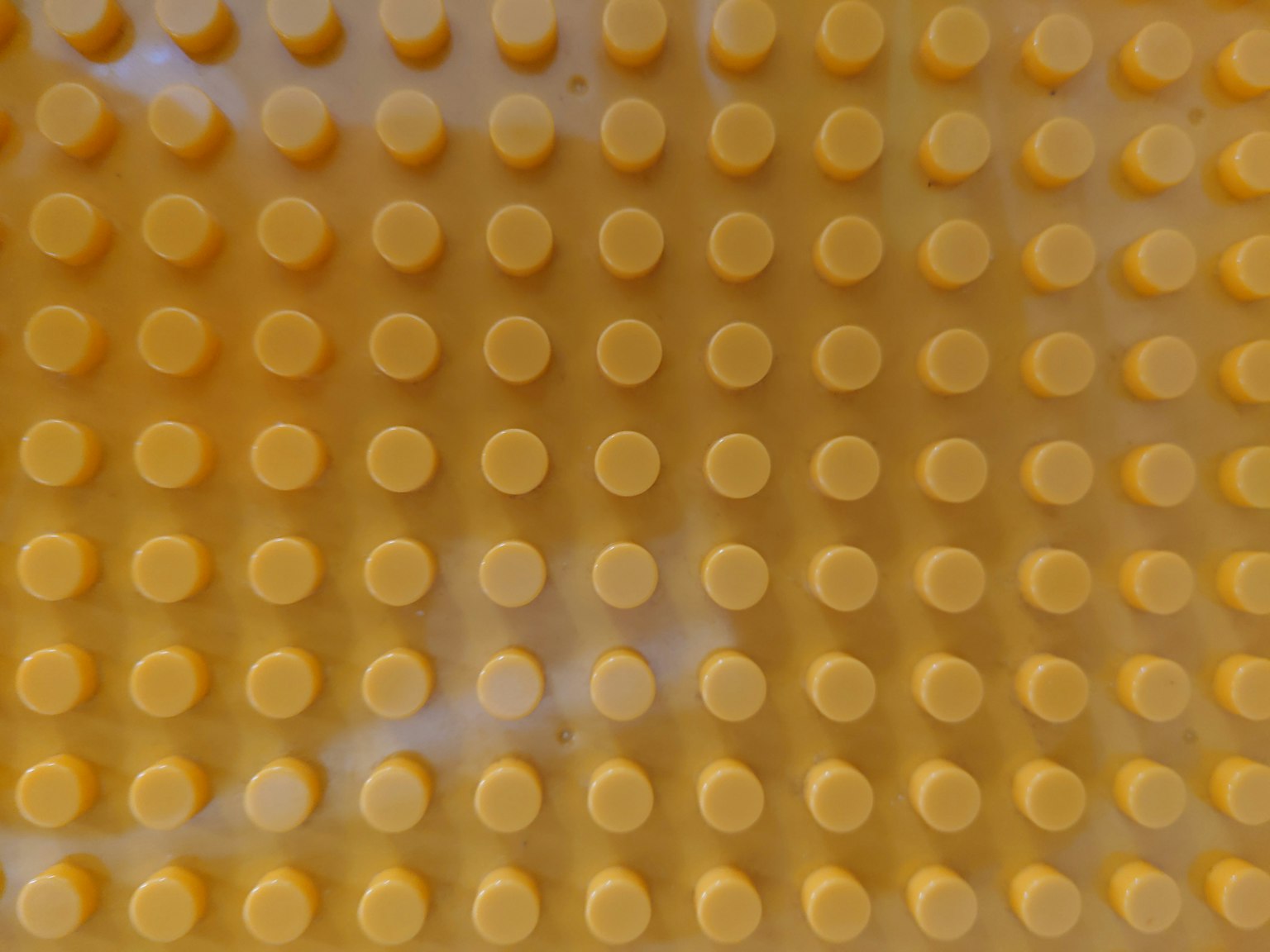 Plastic surface with evenly spaced yellow dots